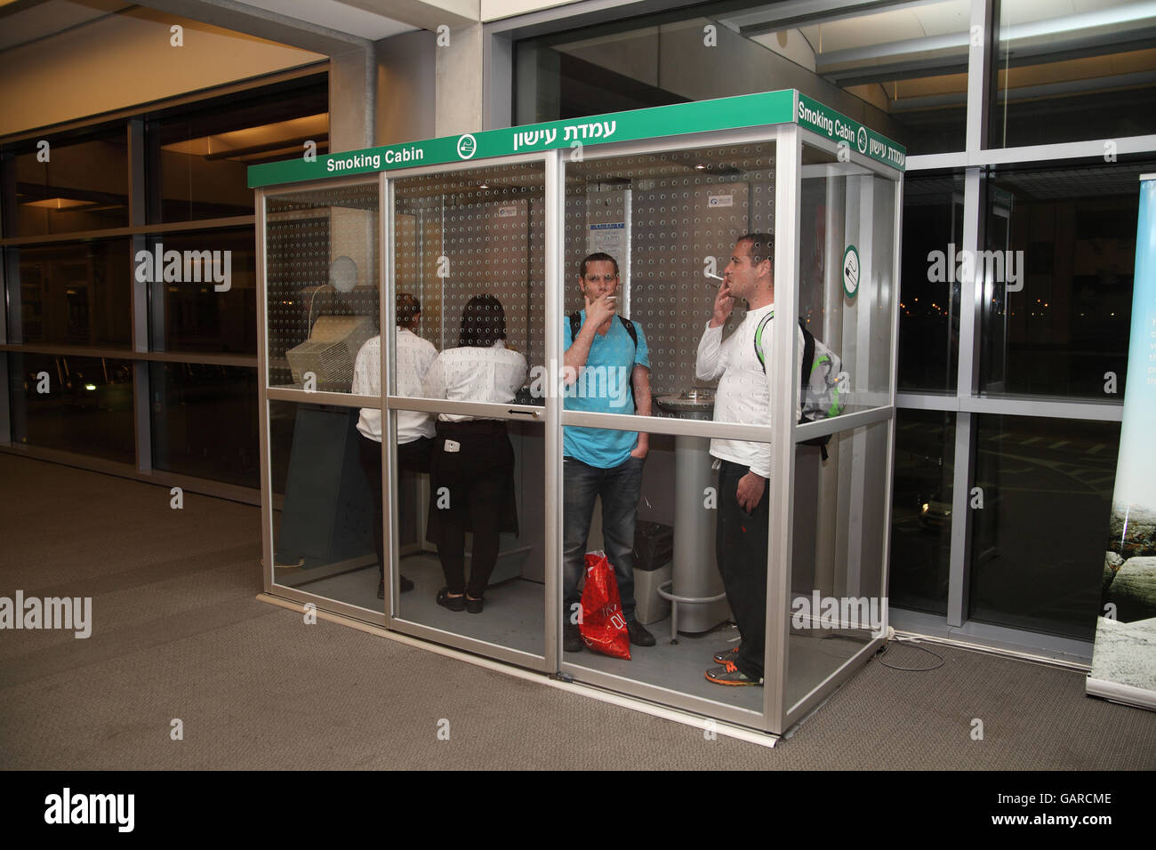 Israelische Raucher stehen in einer Kabine, die speziell für Raucher an der Rauch Rauchen frei Ben Gurion Flughafen in Tel Aviv. LOD oder Lydda, Israel. Stockfoto