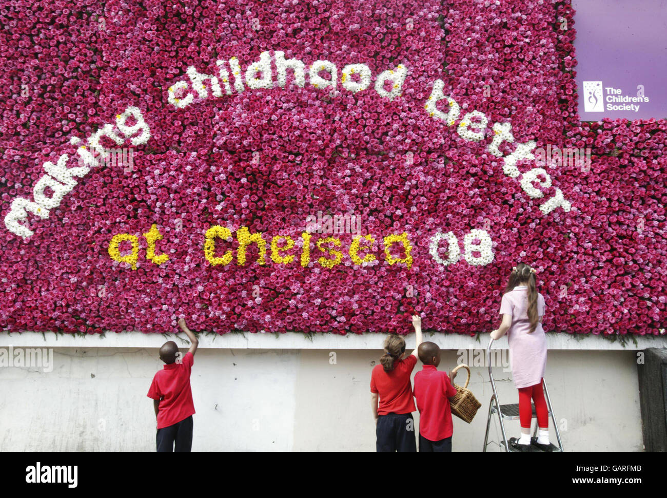 Von links nach rechts. Modou Nusa Ann, Lucy Lord, Cherno Maio Ann und Sidal Durna, alle im Alter von 9 Jahren aus Hackney, helfen, die erste Live-Blumentafel auf der Hassell Street in Hackney zu stellen, um den Garten der Kindergesellschaft auf der RHS Chelsea Flower Show zu feiern. Stockfoto