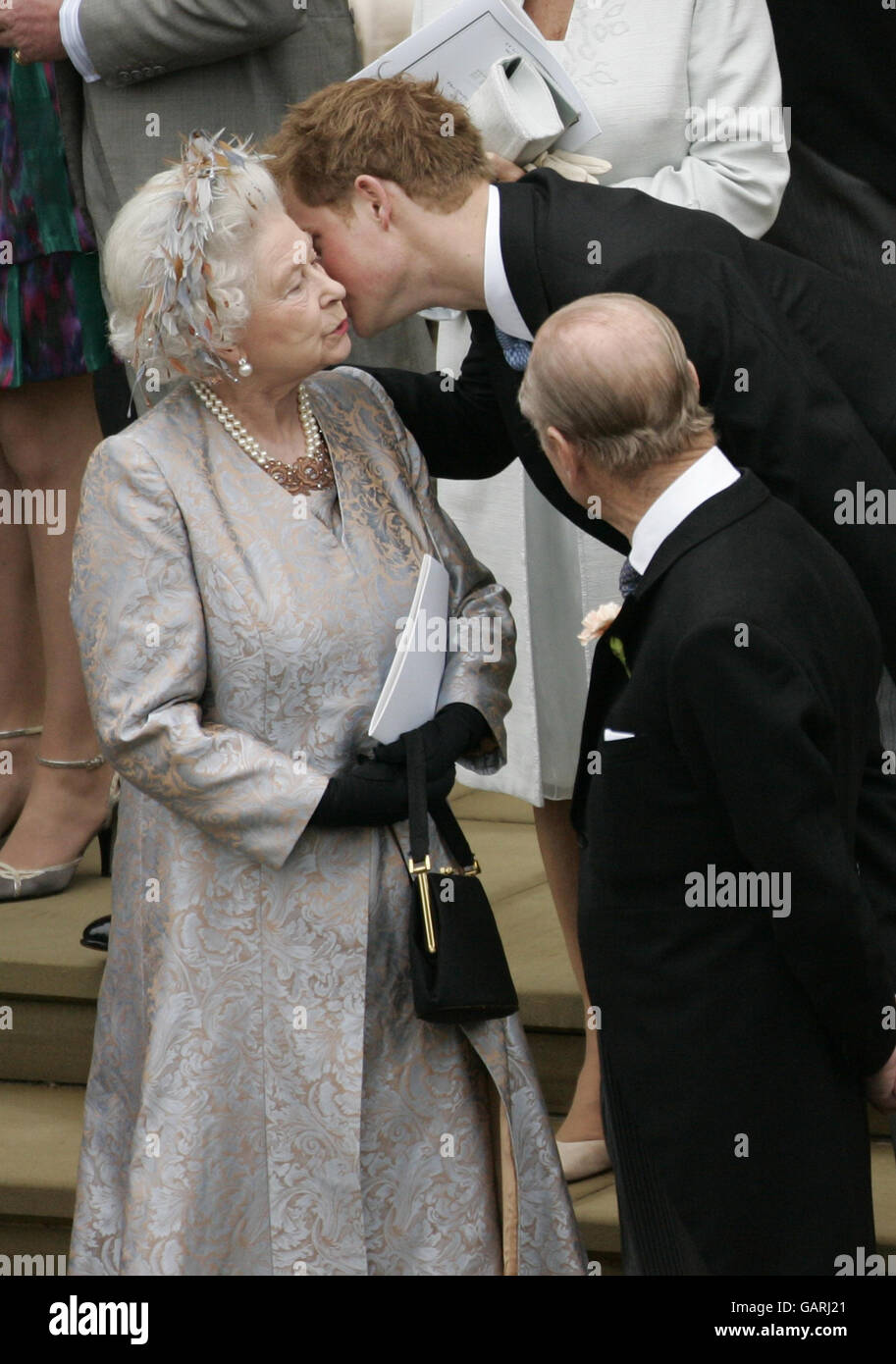 Prinz Harry gibt seiner Großmutter, Königin Elizabeth II., nach der Hochzeit von Peter Phillips und Autumn Kelly einen Kuss vor der St. George's Chapel in Windsor. Stockfoto