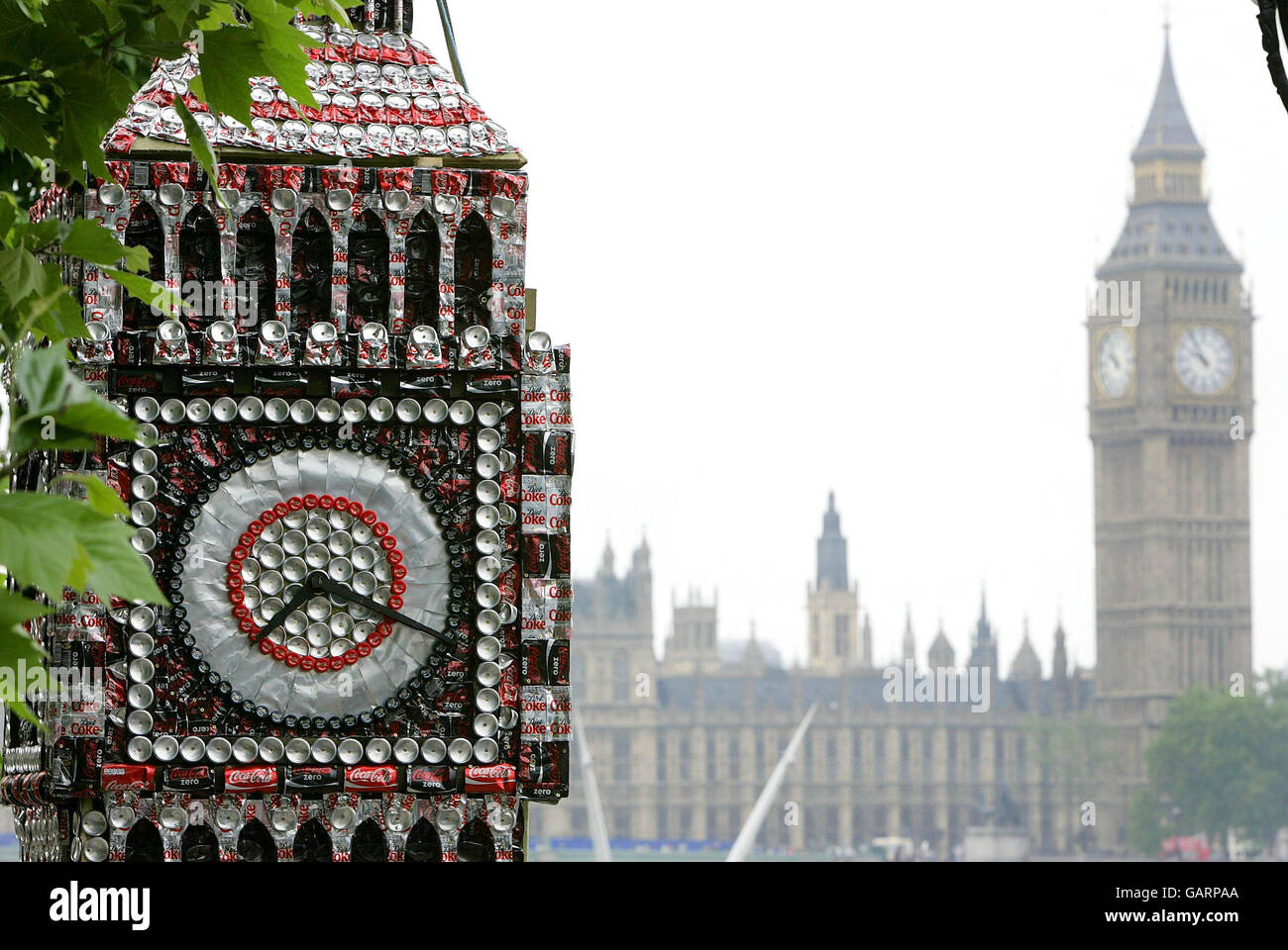 Eine 6 Meter hohe Skulptur von Big Ben aus Coca-Cola-Dosen des Künstlers Robert Bradford am Londoner South Bank. Der echte Big Ben ist im Hintergrund zu sehen. Stockfoto