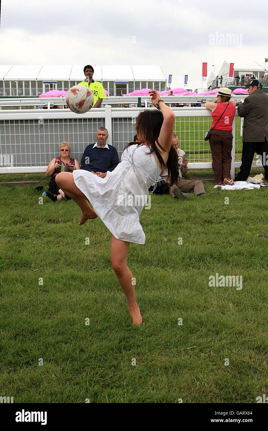 Pferderennen - 2008 Derby Festival - Ladies Day - Epsom Downs Racecourse. Racegoers spielen Fußball-Trackside während des Ladies Day Stockfoto