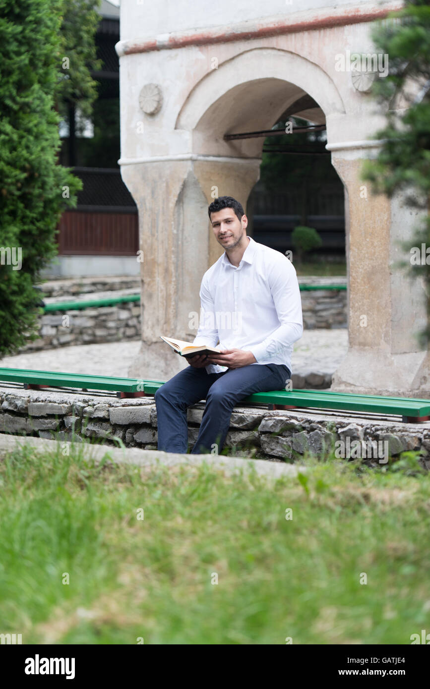 Bescheidenen muslimischer Mann liest das Koran im freien Stockfoto