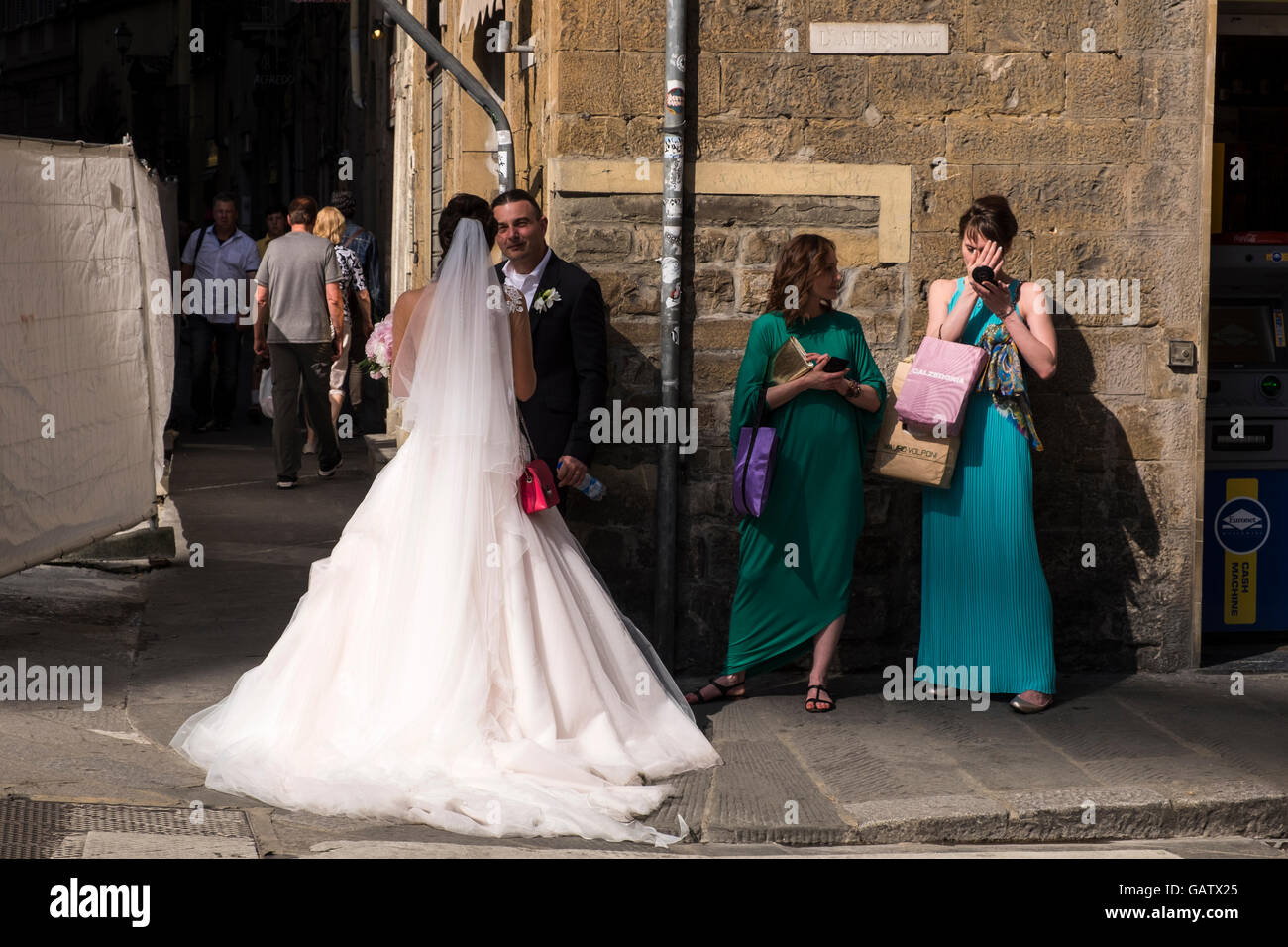 Braut, Bräutigam und Freunden an einer Straßenecke in Florenz, Toskana, Italien. Stockfoto