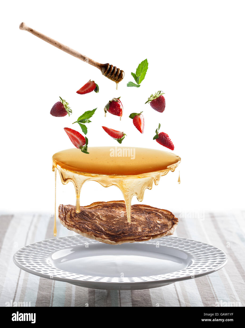 Fliegende Pfannkuchen mit Honig und Erdbeeren Stockfoto