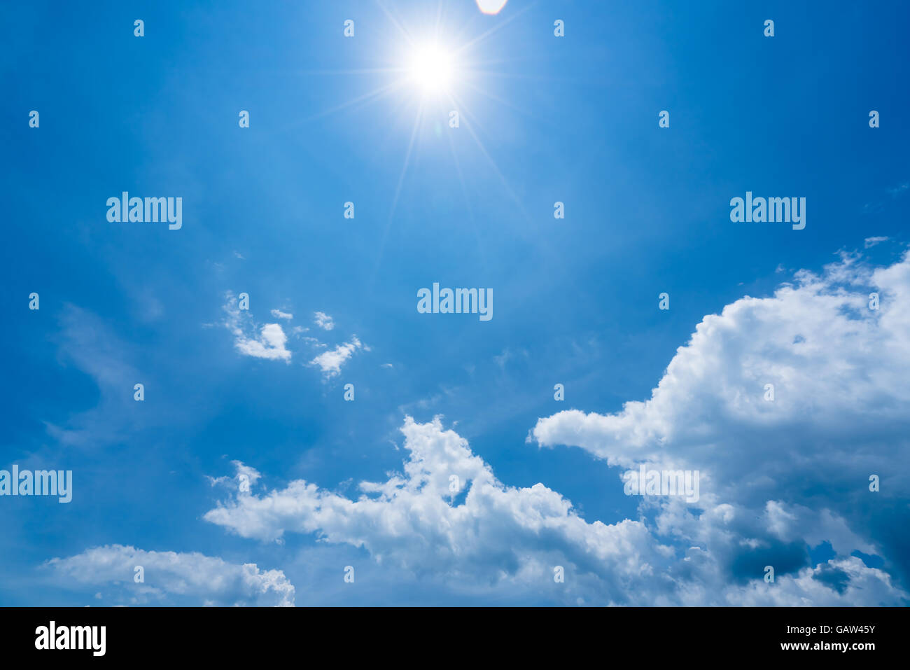 Strahlender Sonnenschein mit Sonne Flares und Wolken am blauen Himmelshintergrund, heißen Sommer Konzept Stockfoto