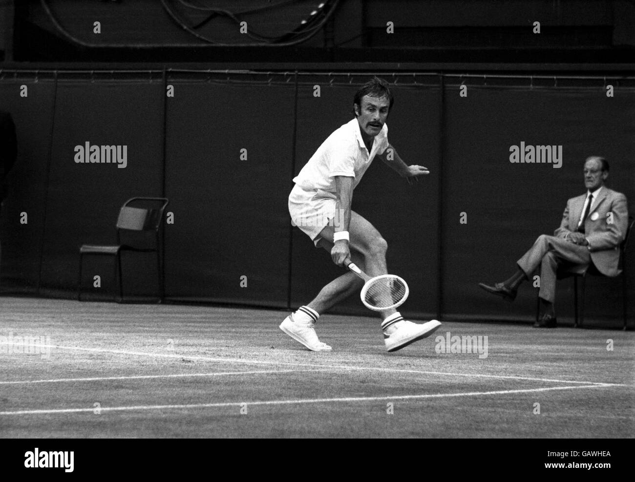 Tennis - Wimbledon Championships. John Newcombe liegt von der Rückseite des Hofes Stockfoto