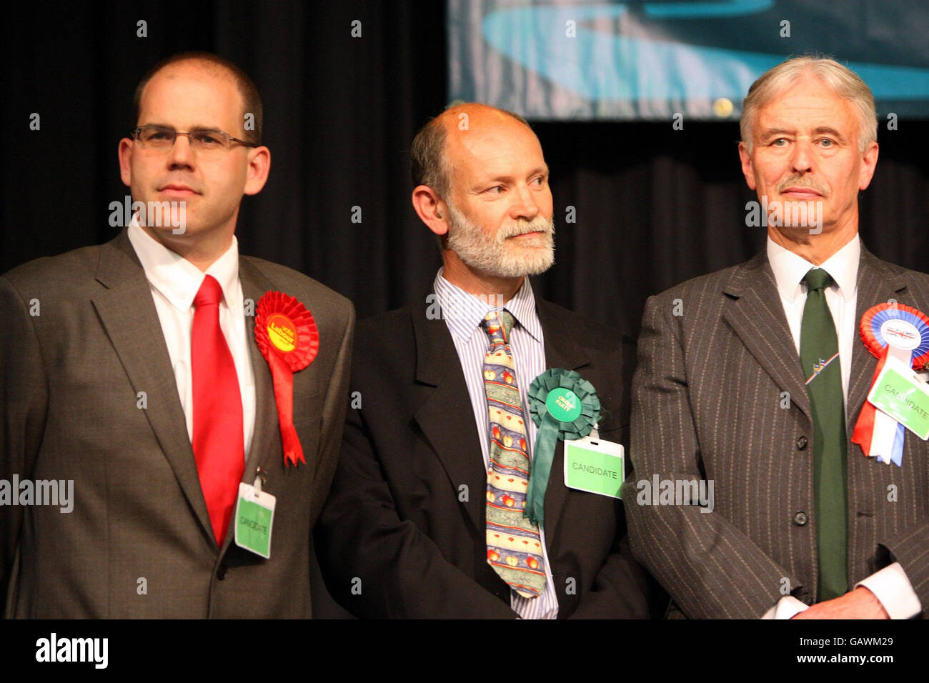 Labour-Kandidat Richard McKenzie (links) steht mit Mark Stevenson (Mitte) von der Grünen Partei und Timothy Rait von der britischen National Party, bevor die Henley-on-Thames Nachwahlergebnisse im Thame Freizeitzentrum in Oxfordshire bekannt gegeben wurden. Stockfoto