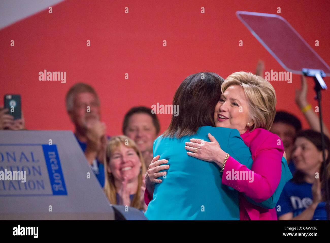 Washington DC, USA. 5. Juli 2016. Am Dienstag, 5. Juli, im Walter E. Washington Convention Center, Lily Eskelsen García, umarmt Secretary Hillary Clinton, die mutmaßlichen demokratischen Präsidentschaftskandidaten, wie sie in der Phase um mehr als 7.500 Delegierten bei der National Education Association (NEA) Adresse 95. repräsentativen Versammlung (RA). Im Oktober empfohlen NEA Pädagogen Außenministerin Clinton in die demokratischen Primary. Bildnachweis: Cheriss Mai / Alamy Live News Stockfoto