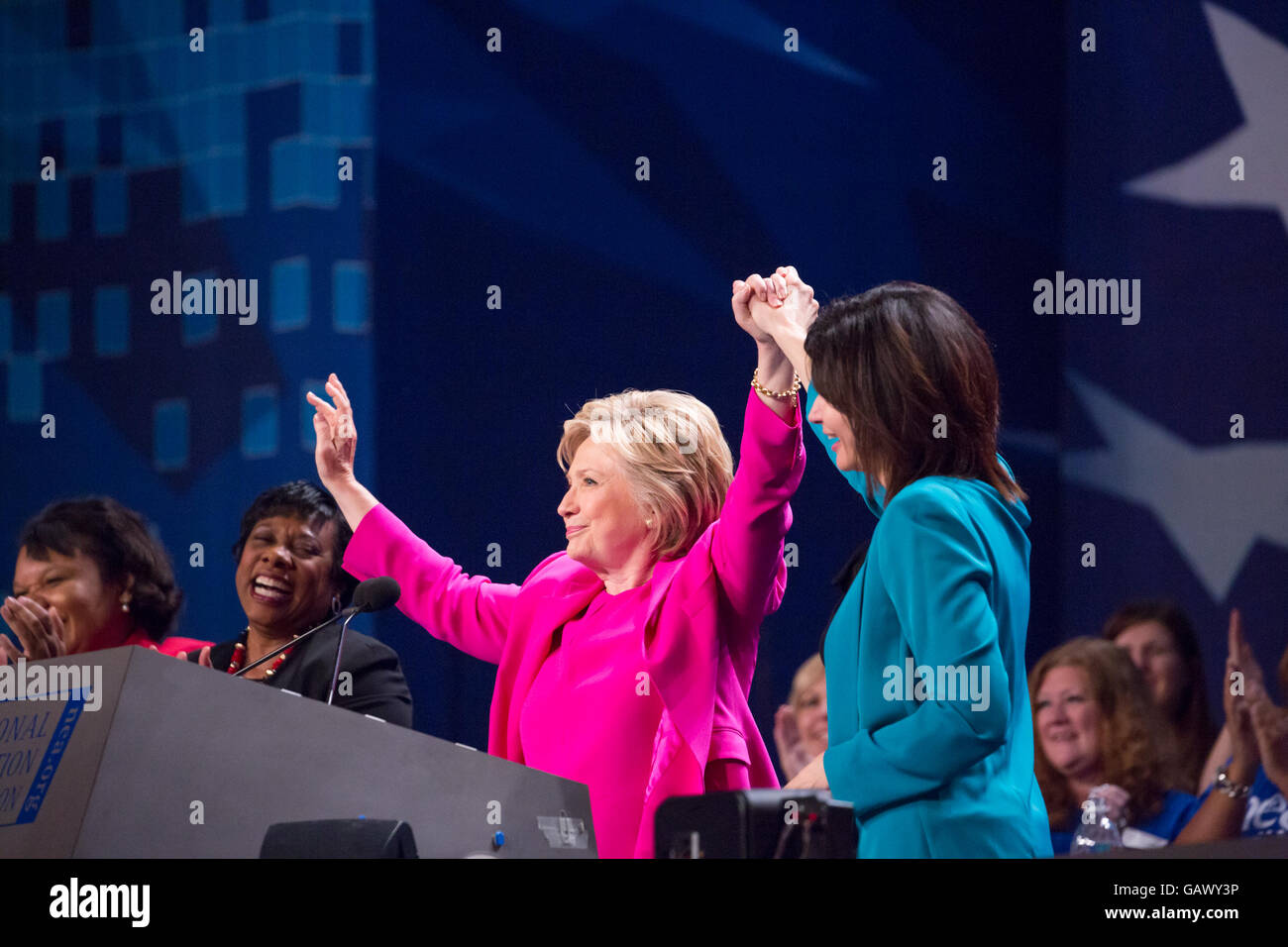 Washington DC, USA. 5. Juli 2016. Am Dienstag, 5. Juli, im Walter E. Washington Convention Center, Lily Eskelsen García hält Secretary Hillary Clinton, die mutmaßlichen demokratischen Präsidentschaftskandidaten in ein Zeichen des Sieges, als sie ihre Adresse mehr als 7.500 Delegierten auf der National Education Association (NEA) fertig 95. repräsentativen Versammlung (RA). Im Oktober empfohlen NEA Pädagogen Außenministerin Clinton in die demokratischen Primary. Bildnachweis: Cheriss Mai / Alamy Live News Stockfoto