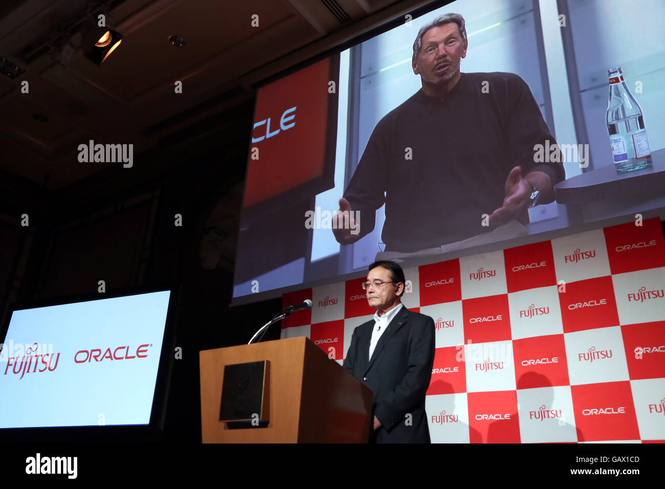 Tokio, Japan. 6. Juli 2016. Amerikanische Cloud-Datenbank Service Giuant Oracle Vorsitzender und Gründer Larry Ellison auf dem Bildschirm und japanischen Computer Riese Fujitsu Vorsitzender Masami Yamamoto sprechen auf einer Pressekonferenz in Tokio am Mittwoch, 6. Juli 2016, wie Fujitsu und Oracle darauf geeinigt, eine neue strategische Allianz um Enterprise Cloud-Services für Kunden in Japan liefern zu bilden. © Yoshio Tsunoda/AFLO/Alamy Live-Nachrichten Stockfoto