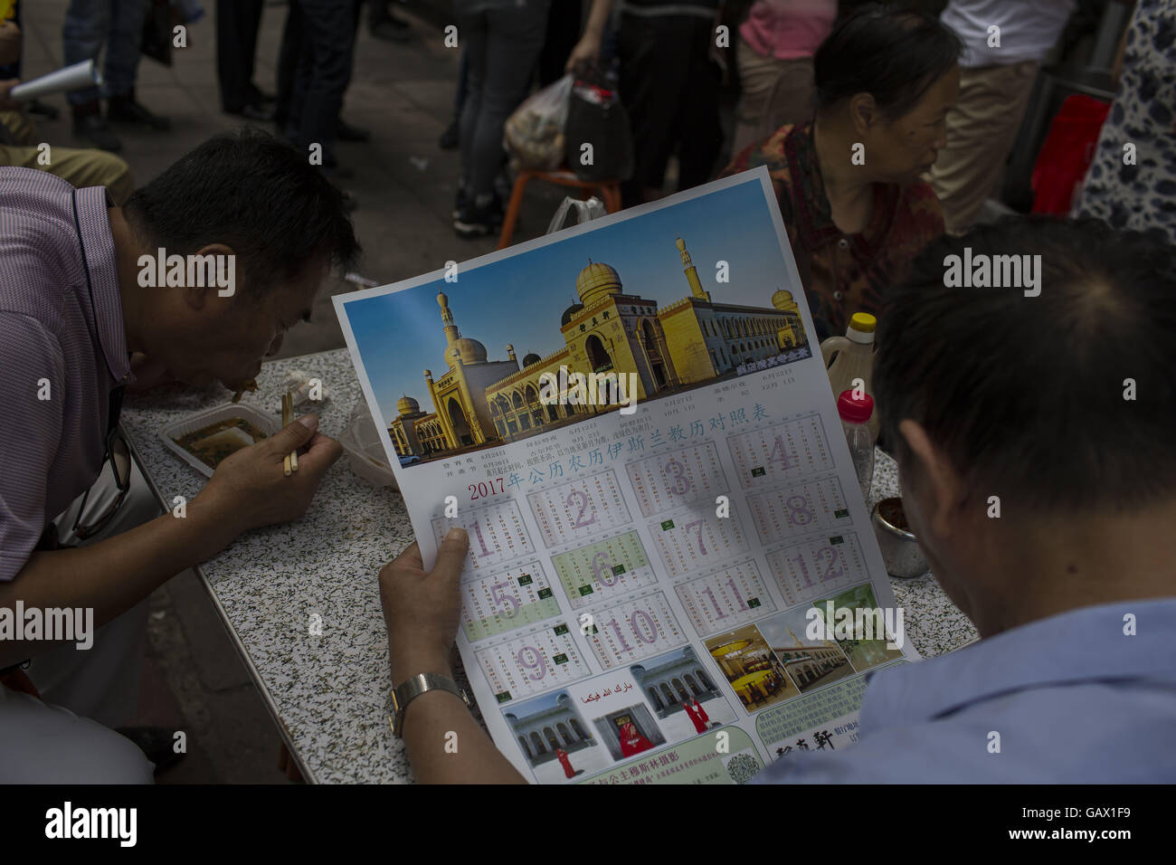 Peking, China. 6. Juli 2016. Ein Mann schaut der muslimische Kalender. Muslime auf der ganzen Welt feiern das religiöse Fest Eid al-Fitr, die signalisiert das Ende des heiligen Fastenmonats Ramadan. Niujie Moschee ist die älteste Moschee in Peking und im 996 n. Chr. erbaut wurde. Bildnachweis: Jiwei Han/ZUMA Draht/Alamy Live-Nachrichten Stockfoto