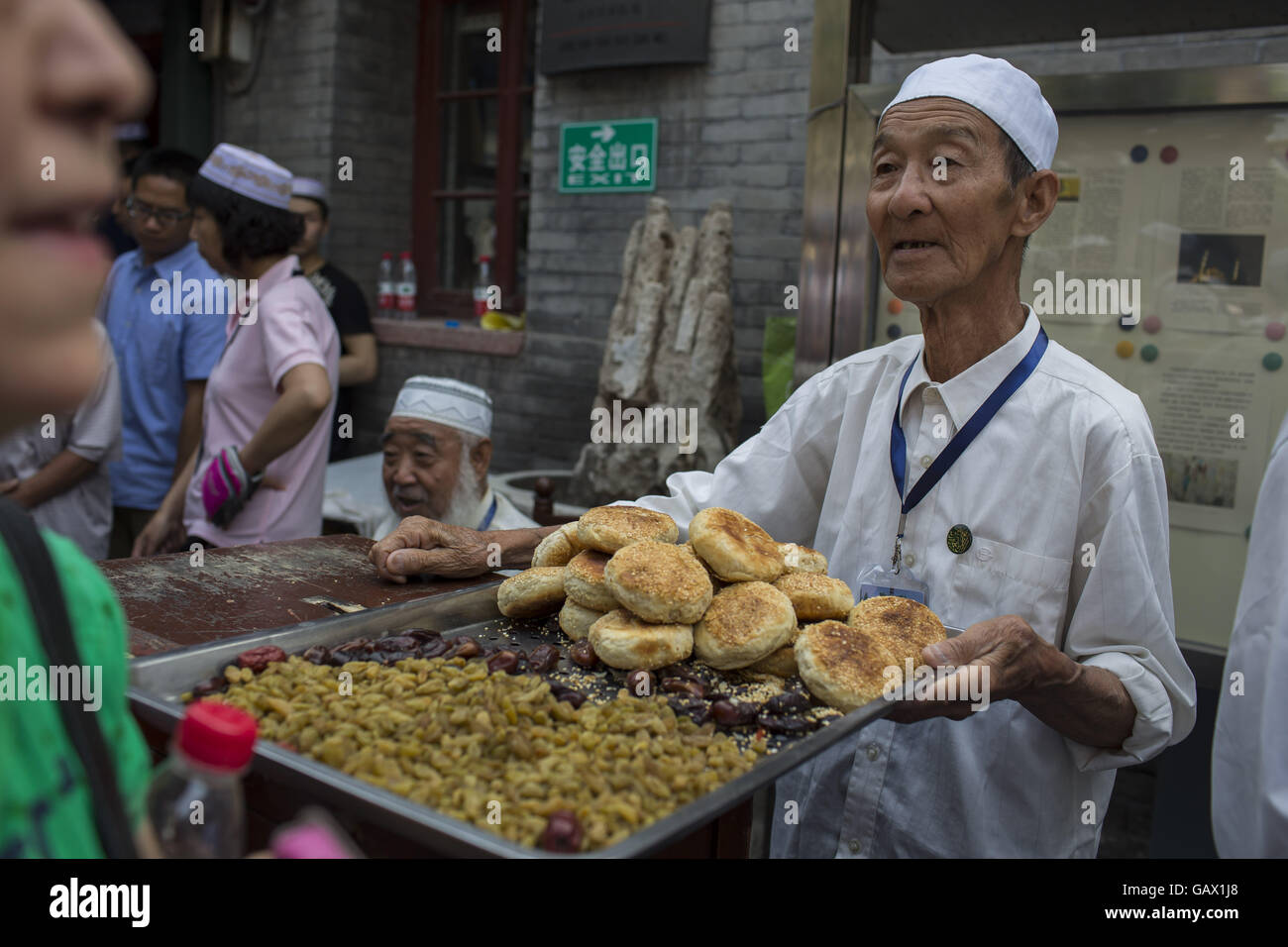 Peking, China. 6. Juli 2016. Eine alte muslimische teilt Lebensmittel an andere Muslime in Niujie Moschee, die Eid al-Fitr zu feiern. Muslime auf der ganzen Welt feiern das religiöse Fest Eid al-Fitr, die signalisiert das Ende des heiligen Fastenmonats Ramadan. Niujie Moschee ist die älteste Moschee in Peking und im 996 n. Chr. erbaut wurde. Bildnachweis: Jiwei Han/ZUMA Draht/Alamy Live-Nachrichten Stockfoto