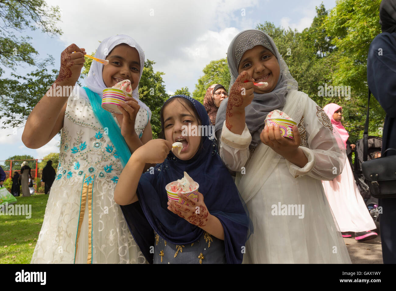 Drei jungen asiatischen Briten Mädchen essen Eis nach dem Gebete bei kleinen Heide Park Birmingham UK Eid 2016 Stockfoto