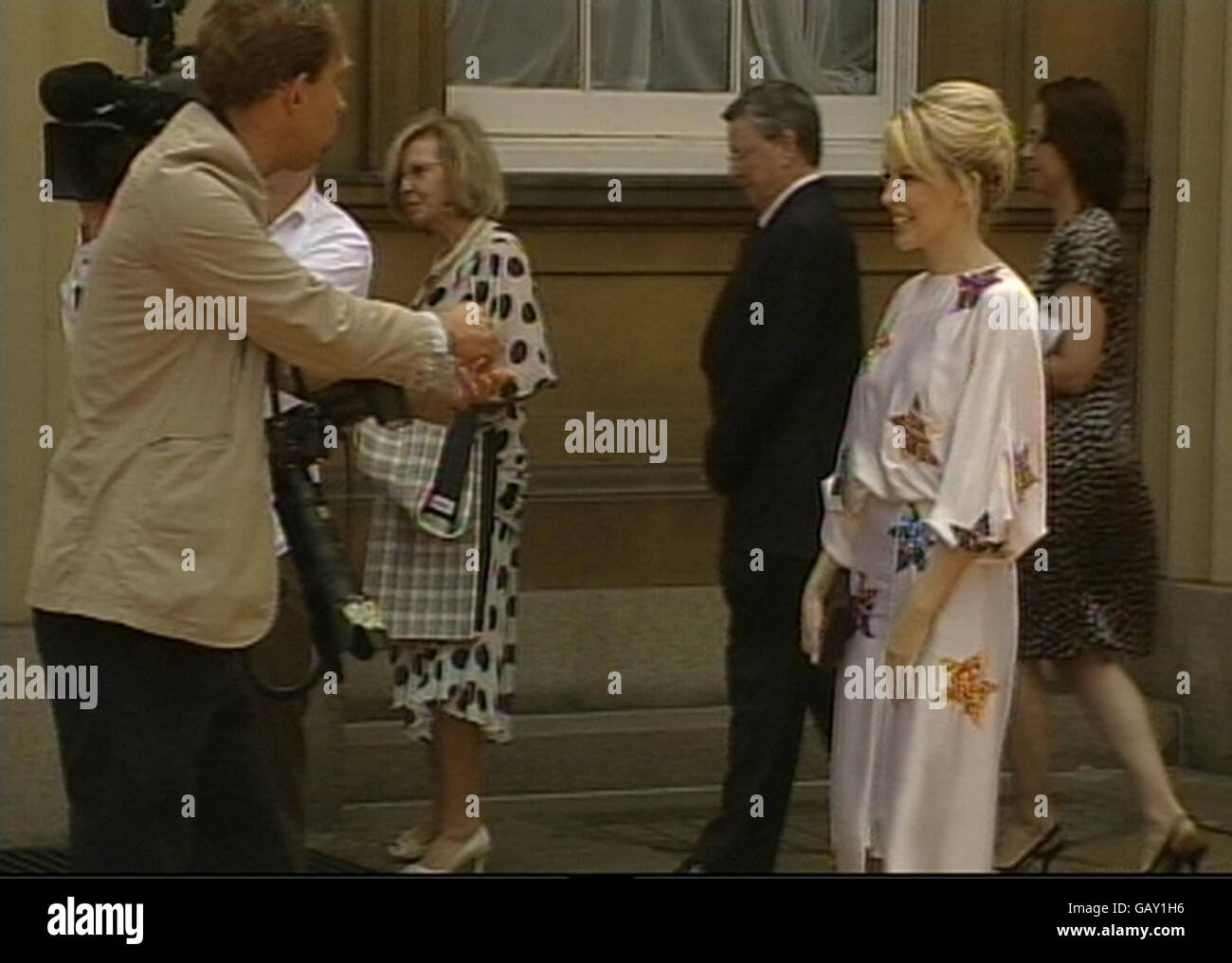 Presseverband Fotograf Stefan Rousseau bei der Arbeit im Innenhof des Buckingham Palace fotografiert die australische Sängerin Kylie Minogue, nachdem sie ihre OBE vom Prince of Wales nach einer Investiturzeremonie erhielt. Stockfoto