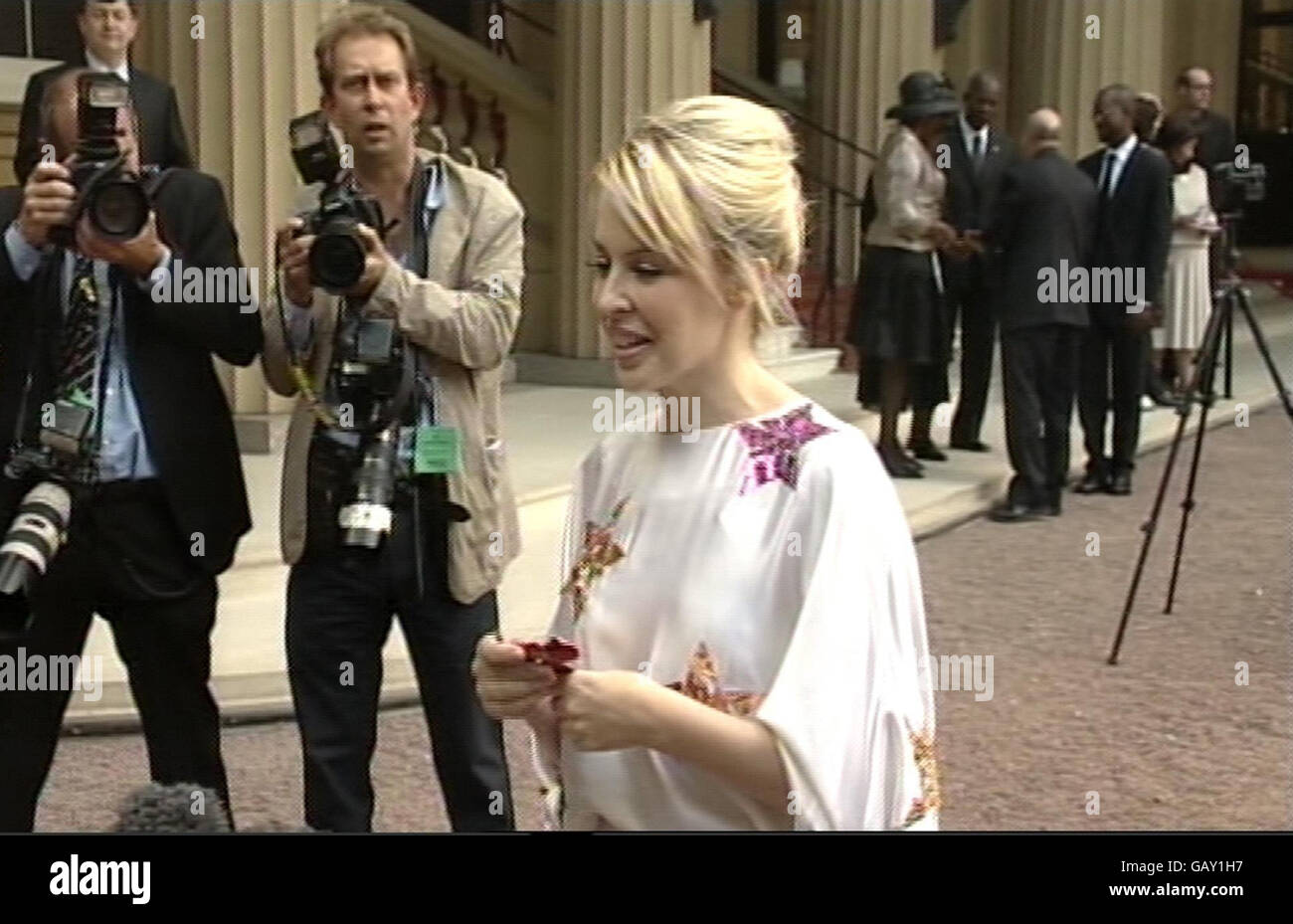 Presseverband Fotograf Stefan Rousseau bei der Arbeit im Innenhof des Buckingham Palace fotografiert die australische Sängerin Kylie Minogue, nachdem sie ihre OBE vom Prince of Wales nach einer Investiturzeremonie erhielt. Stockfoto