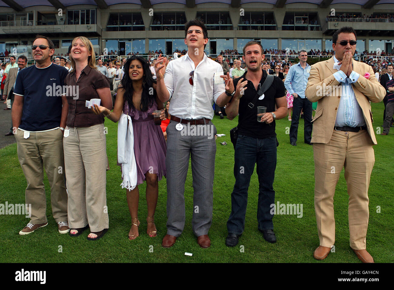 Racegoers genießen die Atmosphäre, während sie das Rennen anfeuern, während des Property Day auf der Sandown Park Racecourse. Stockfoto