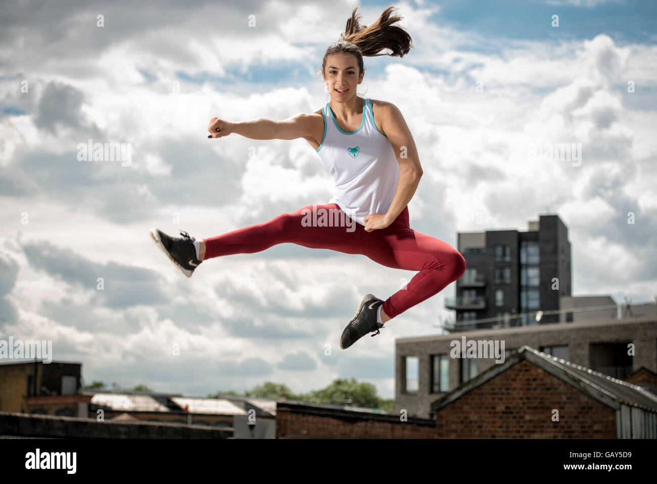 Sportliche Frau trägt Fitness tragen in die Luft springen Stockfoto
