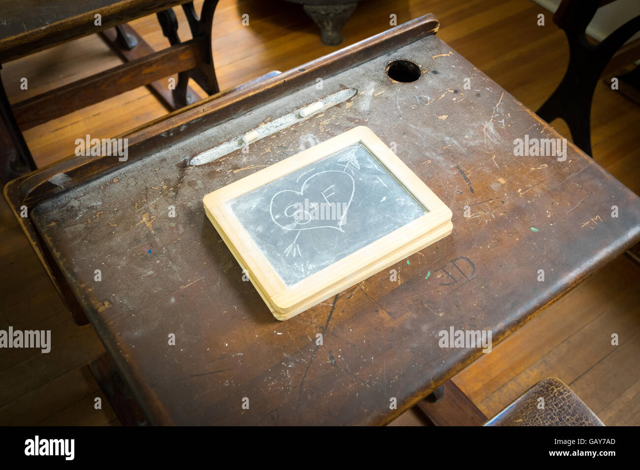 Ein Herz und Initialen auf Vintage Schiefer Tafel, auf einem alten Schreibtisch in einem alten Klassenzimmer im St. Antonius Schule, Fort Edmonton Park, Edmonton, Alberta. Stockfoto