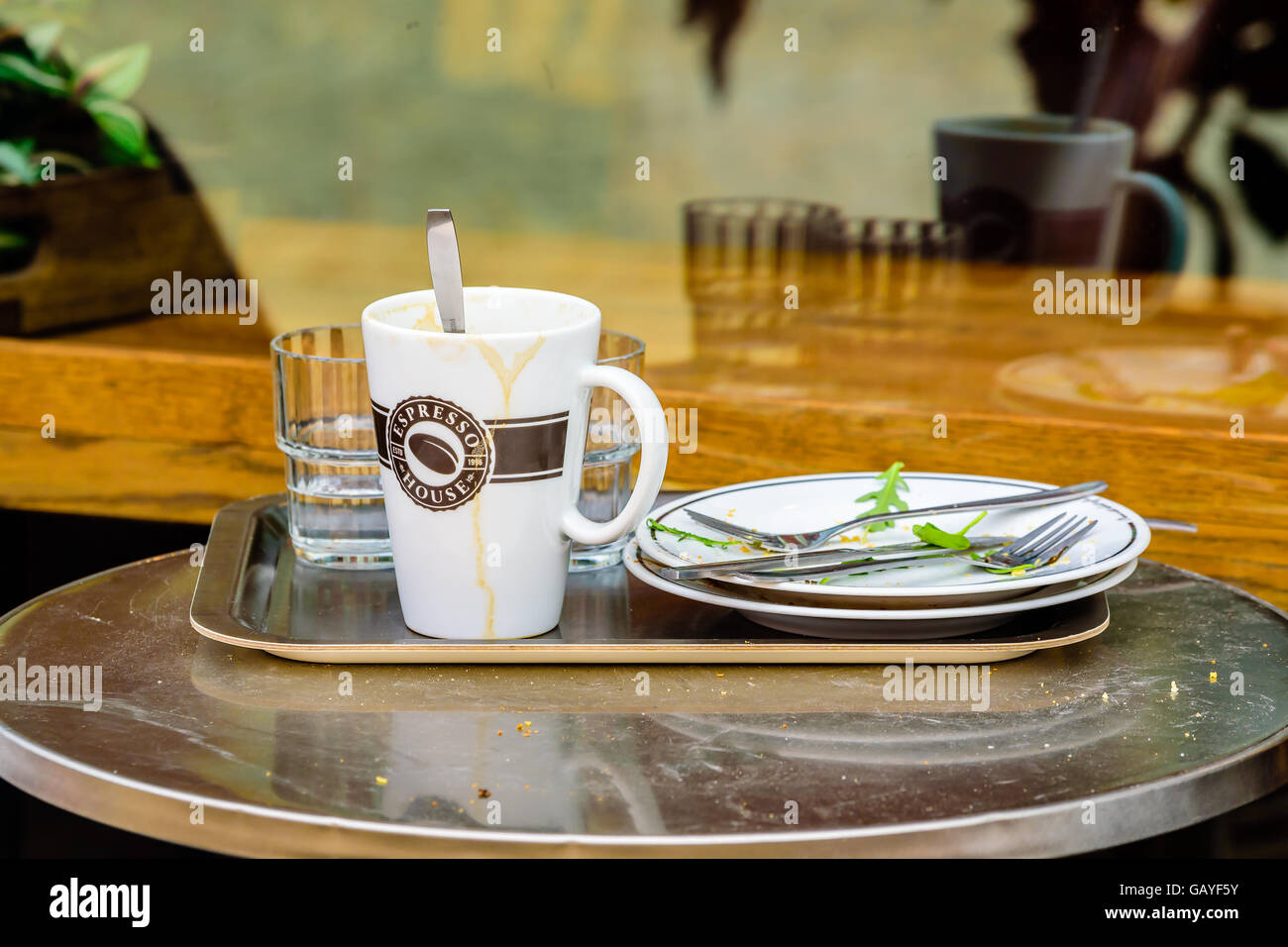 Motala, Schweden - 21. Juni 2016: Schmutziges Geschirr auf kleinen schmutzigen Tisch im Café im Freien. Realen Lebenssituation. Stockfoto