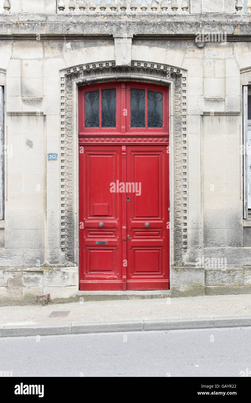 Roten hölzernen Doppeltüren am Eingang zu einem alten Steingebäude in Frankreich Stockfoto