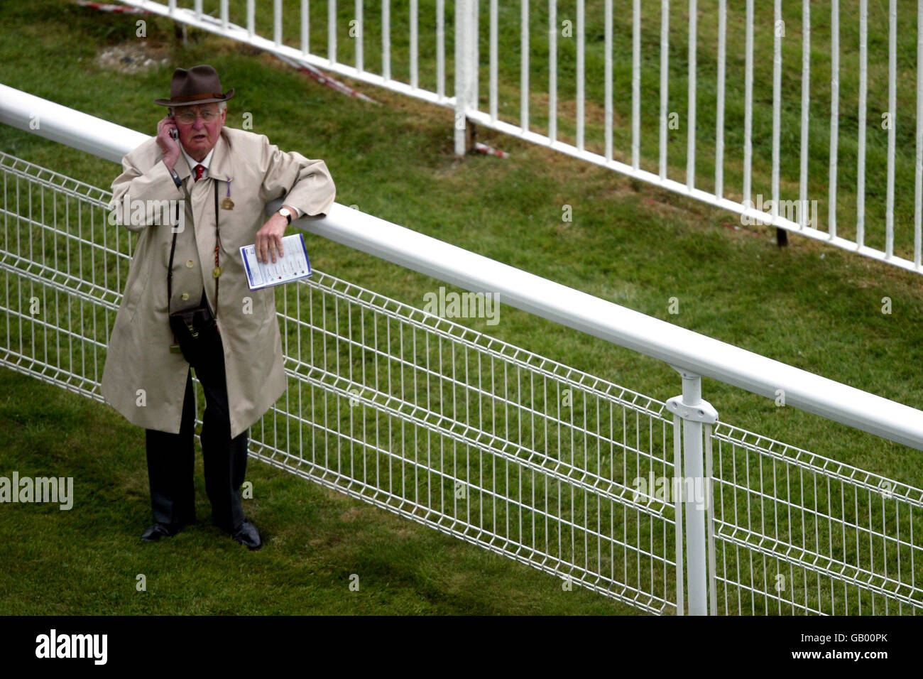 Pferderennen - Epsom - Oaks Day Meeting. Ein Rennfahrer wird über sein Mobiltelefon einen Tipp erhalten Stockfoto