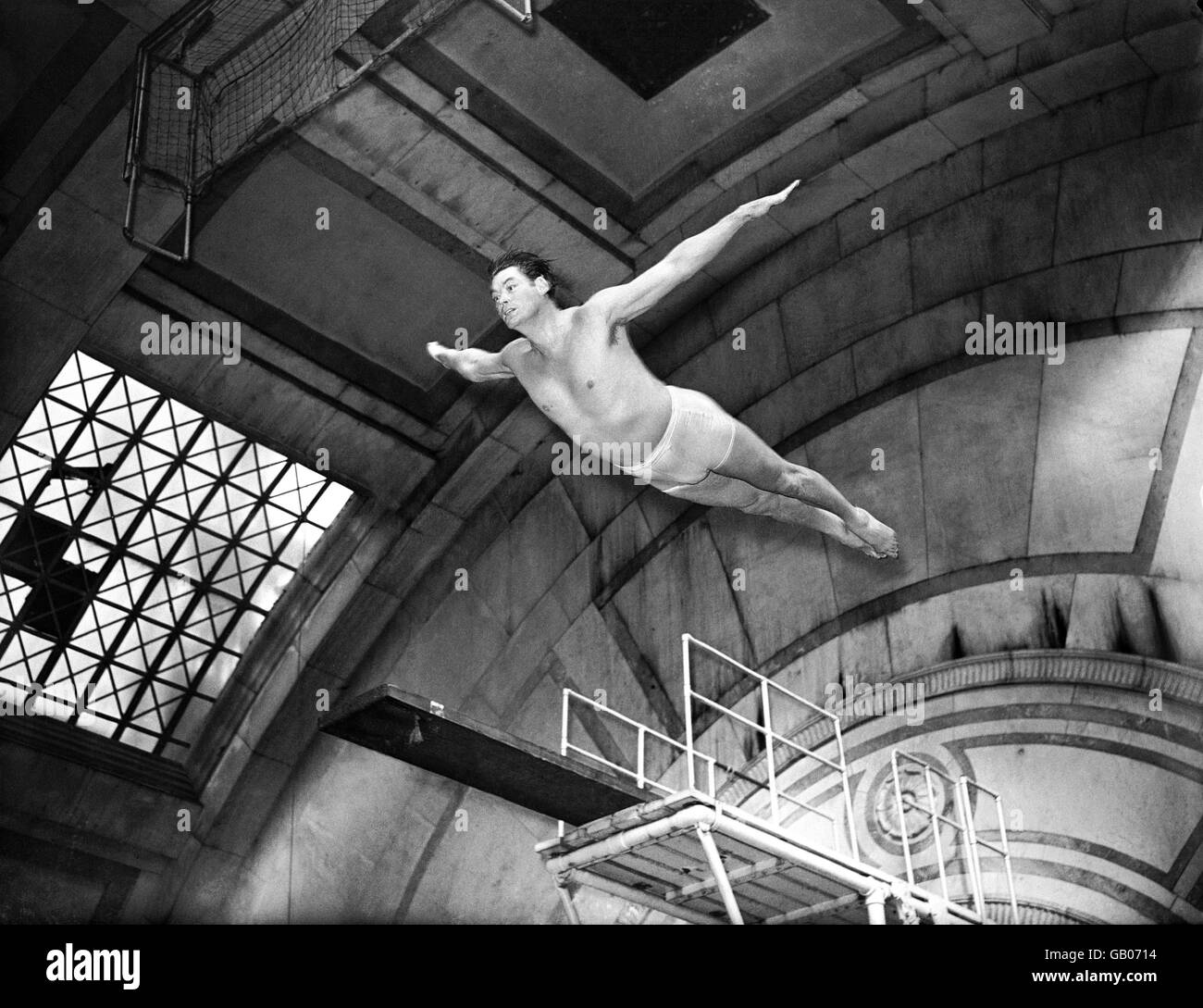 Johnny Weissmuller zeigt perfekte Form, als er in den Pool taucht. Stockfoto