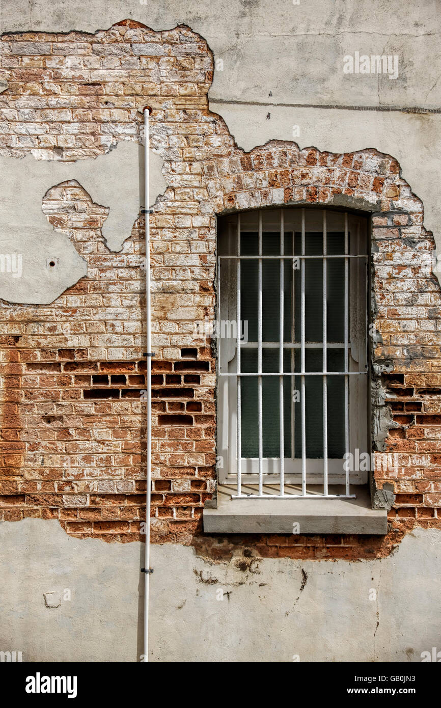 Alte Fenster mit Bars eingelassen verfallenden Ton Ziegelmauer, Albany Western Australia Stockfoto