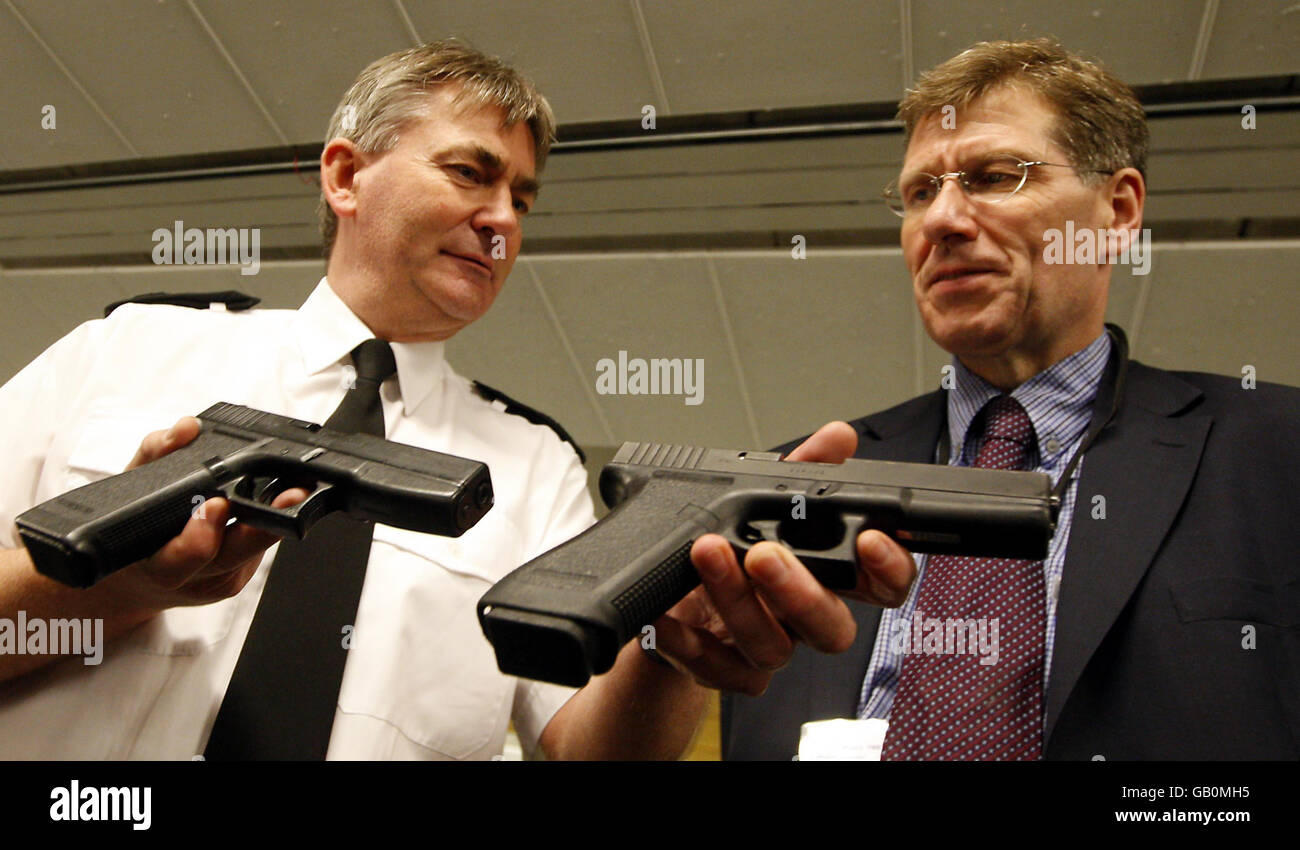 Assistant Chief Constable Jim Green (links) zeigt Justizminister Kenny McCaskill eine echte und eine nachgebaute Handfeuerwaffe. Stockfoto