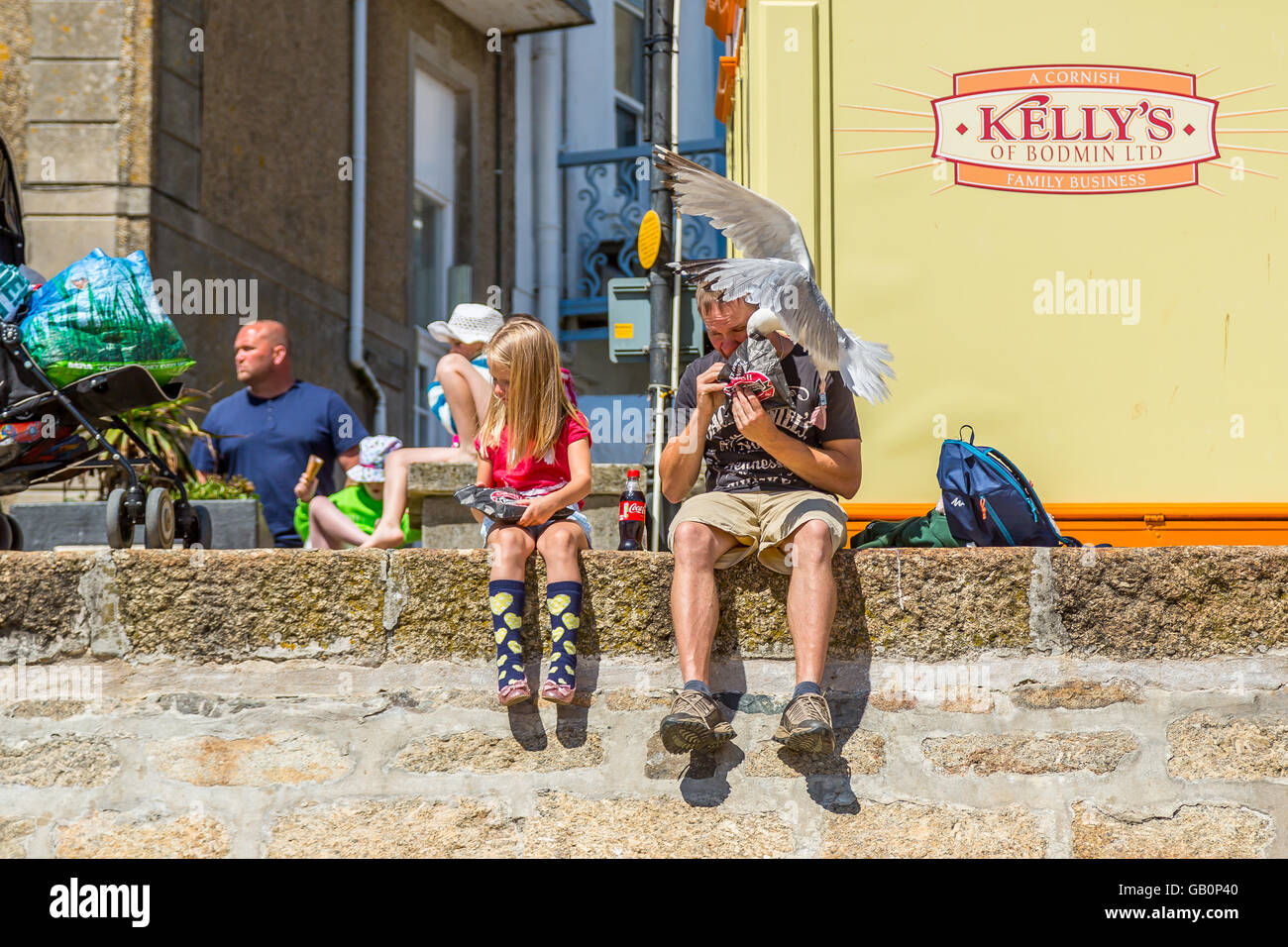 Nr. 1 der 3 Schuss Sequenz zeigt einer Möwe Angriff auf ein Urlauber einen Diebstahl einer pastös in St. Ives, Cornwall Stockfoto