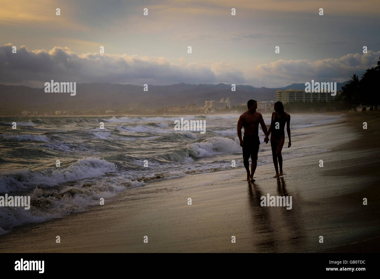 Silhouette von Mann und Frau Wlaking hand an einem Strand an der Riviera Nayarit, Mexiko Stockfoto