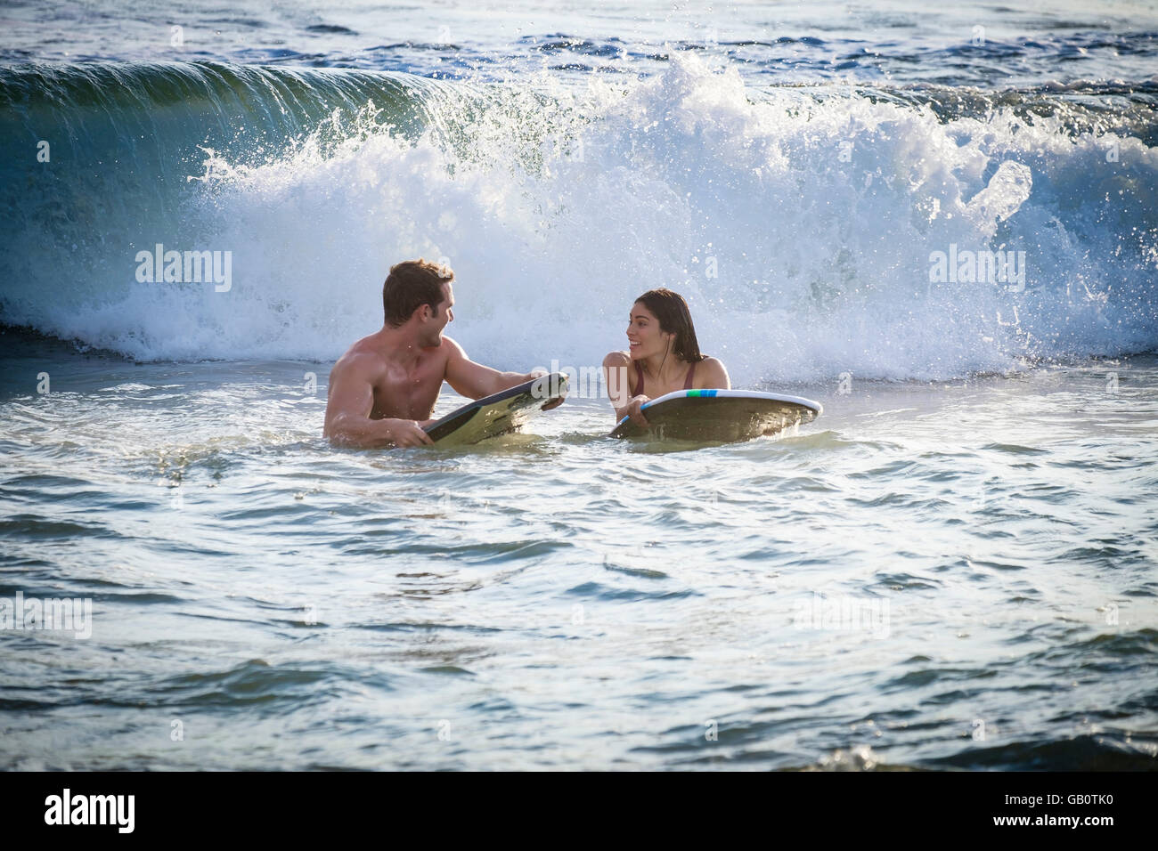 Junge Frau und Mann warten auf Welle auf Boogie board Stockfoto