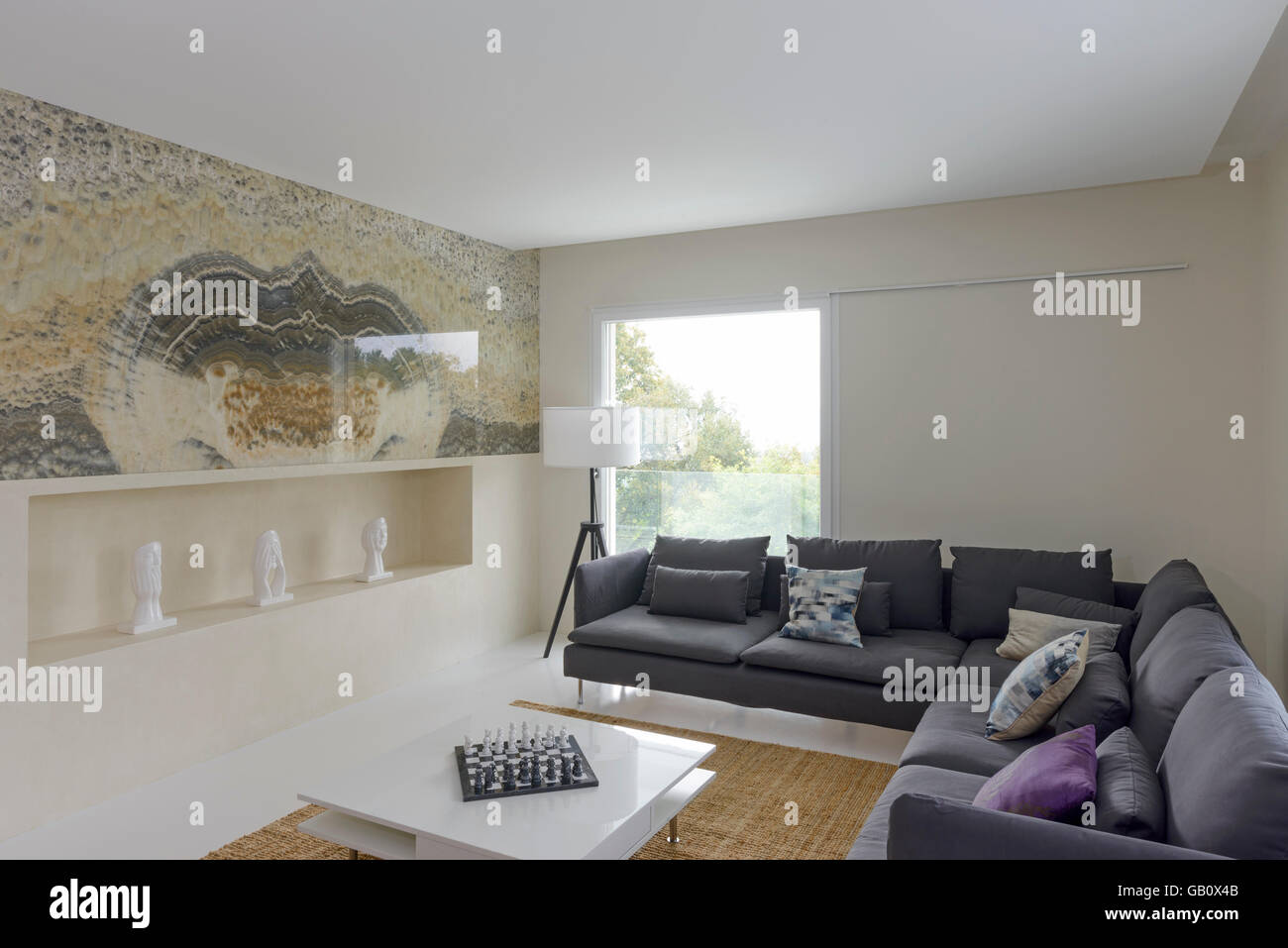 Modernes Wohnzimmer mit großen Sofas und hellen großen Fenstern Stockfoto