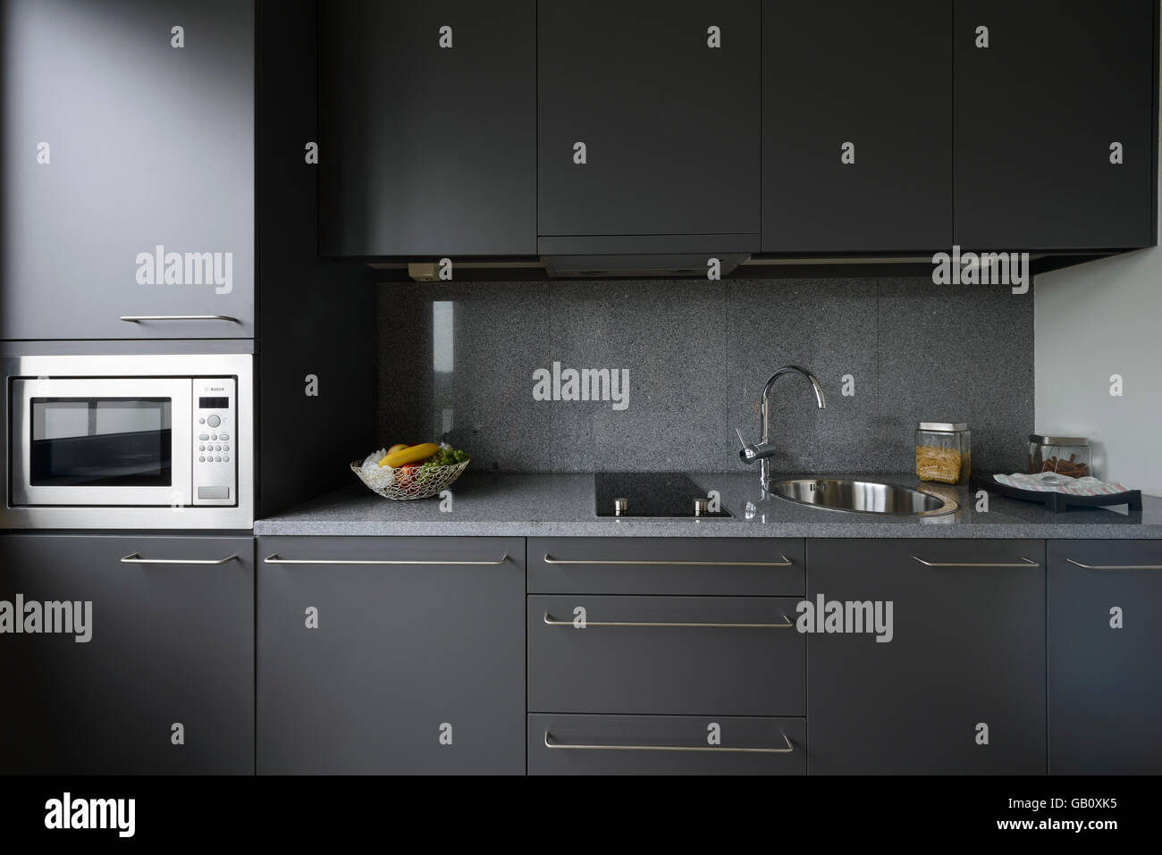 Kleine moderne graue Küchentheke mit Mikrowelle Stockfoto