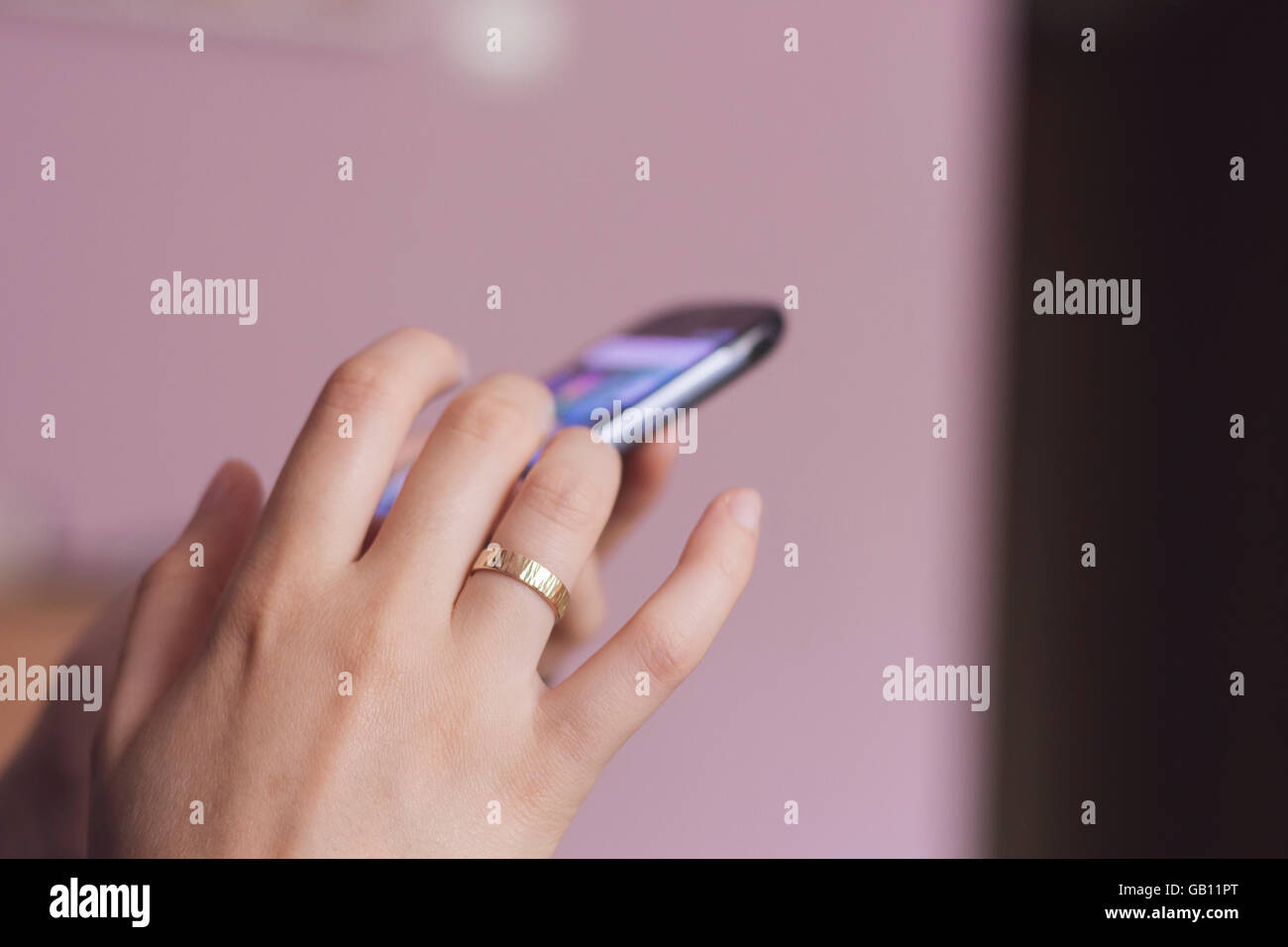 Zarte Frauenhand Scrollen auf ein smart phone Stockfoto