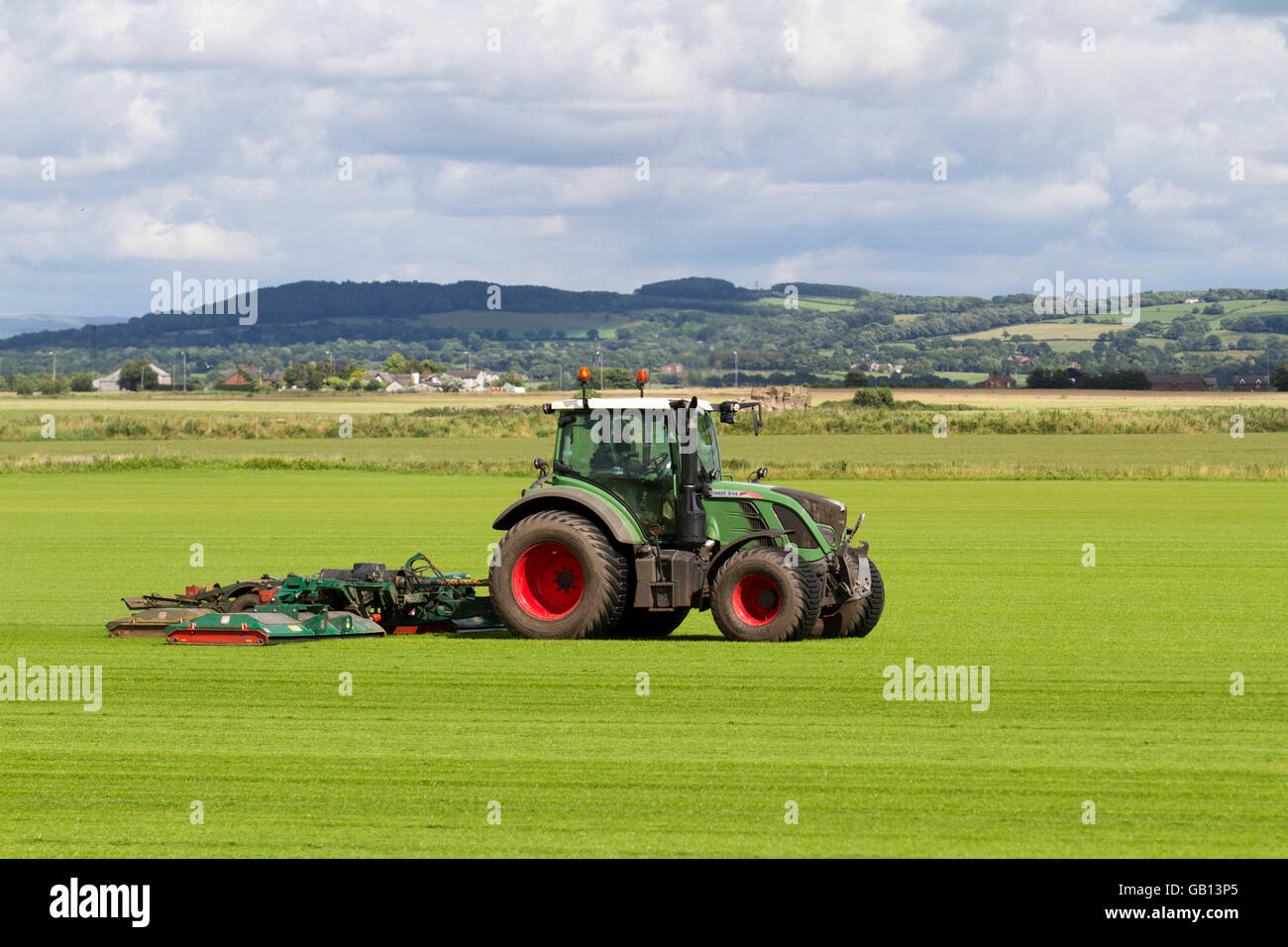 Ein landwirtschaftlicher Rasenmäher in Burscough, Lancashire, Großbritannien, fährt mit einem Fendt 514 Vario-Traktor, der eine neue Grasernte, Grün, Gras, Natur, Rasen mäht, wachsen, Pflanzen, wachsen, Feld, Hintergrund, Wiese, Frühling, Natur, Sommer, Garten, Umwelt, angebaut für die lokale Nachfrage nach Rasen. Auf diesen Feldern wird dieses Jahr Gras angebaut, das Teil des Fruchtwechselsystems der Landwirte ist. Das Prinzip der Fruchtfolge besteht darin, jedes Jahr bestimmte Gruppen von Gemüse in verschiedenen Teilen des Betriebs anzubauen. Stockfoto