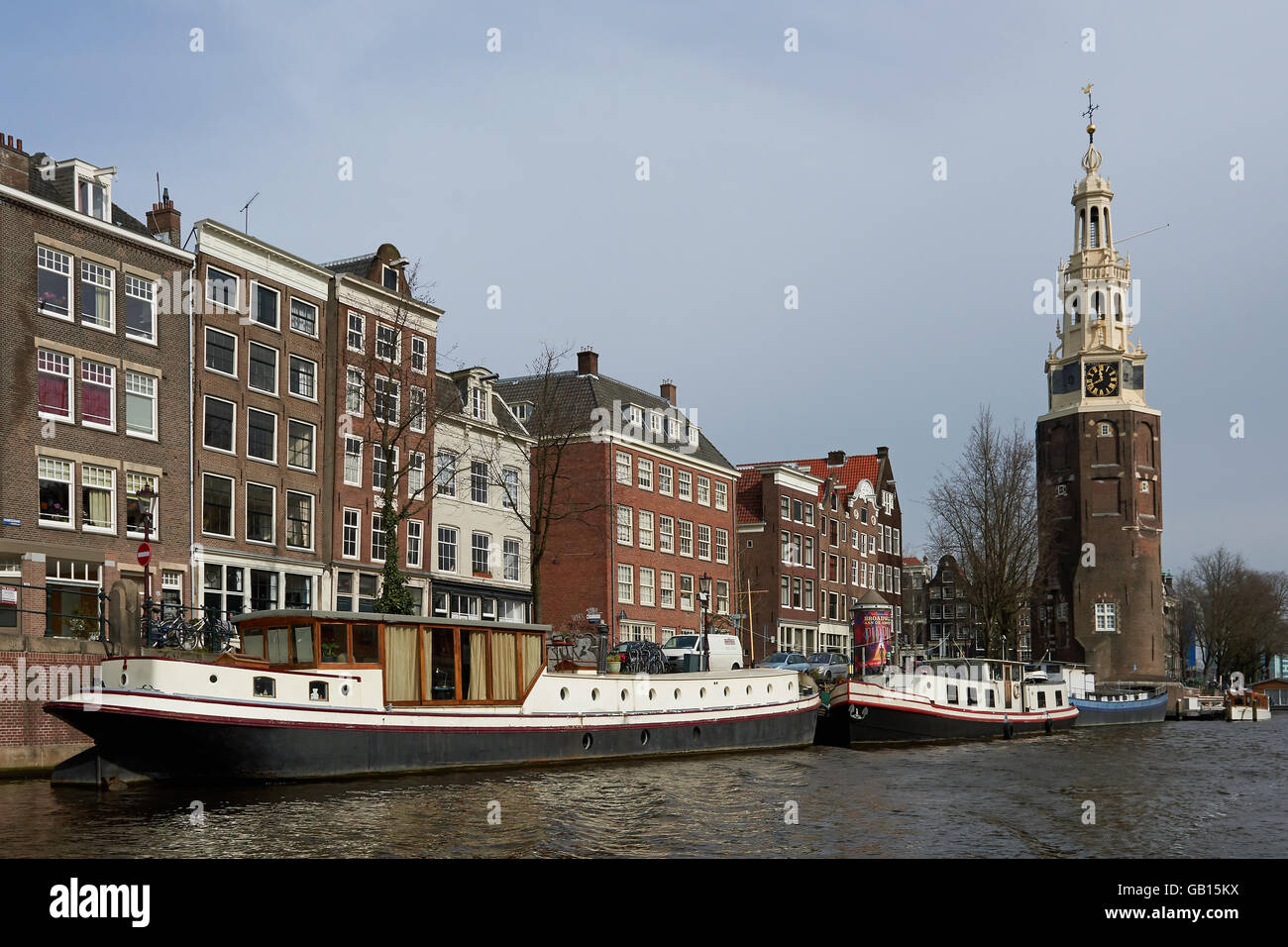 Amsterdam, Niederlande – 9. März 2016: Kanal und Häuser in Amsterdam, mit blauem Himmel im Hintergrund Stockfoto