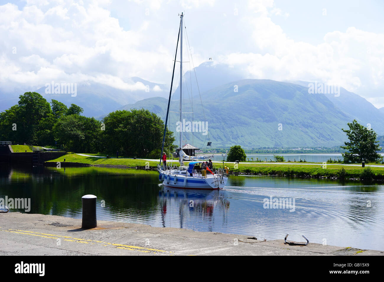 Segelboot betreten die erste Schleuse auf dem Caledonian Canal bei Corpach mit Ben Nevis in niedrigen Wolken, Corpach, Schottland, Großbritannien. Stockfoto