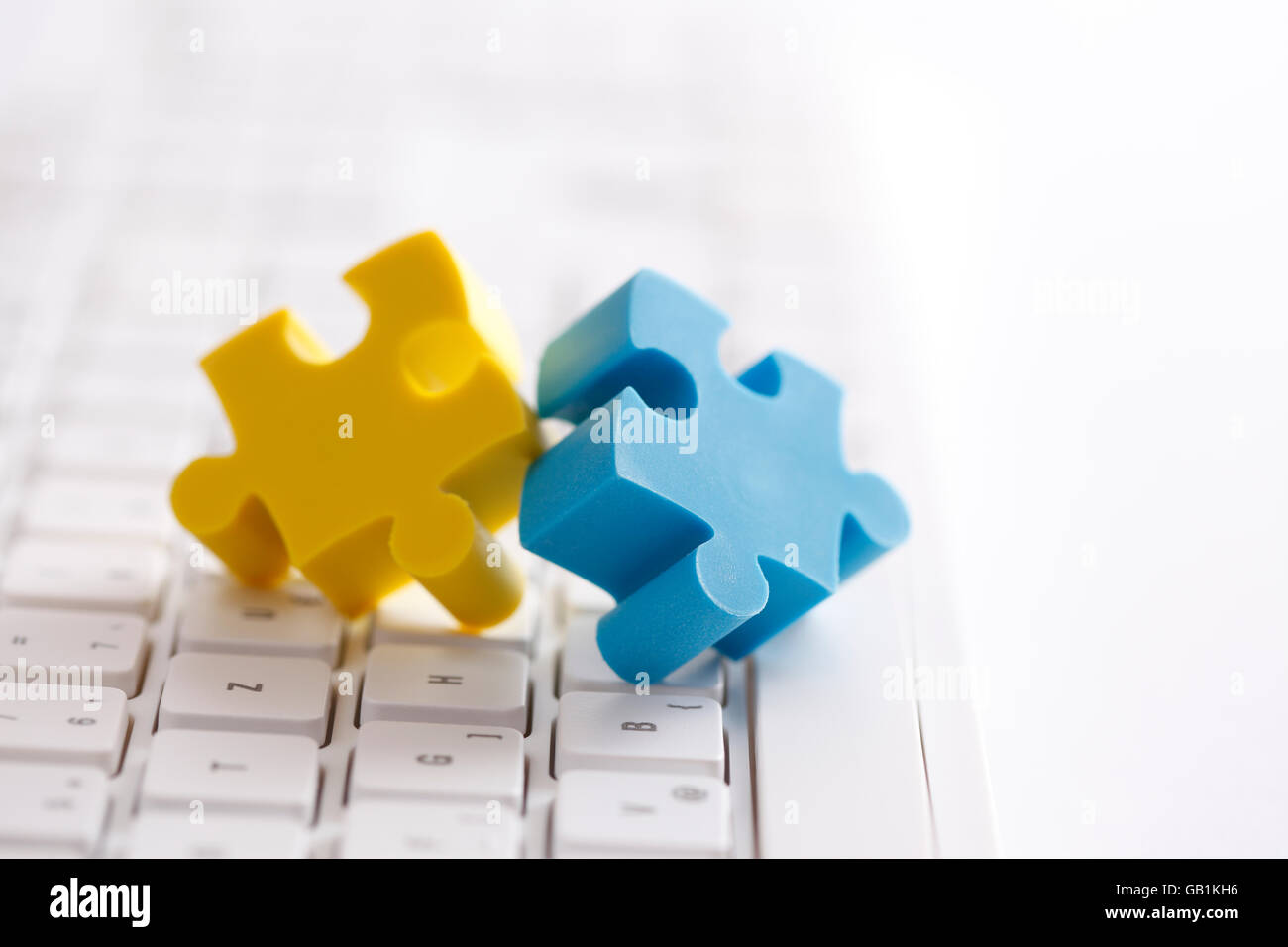 Zwei Puzzleteile auf Computer-Tastatur Stockfoto