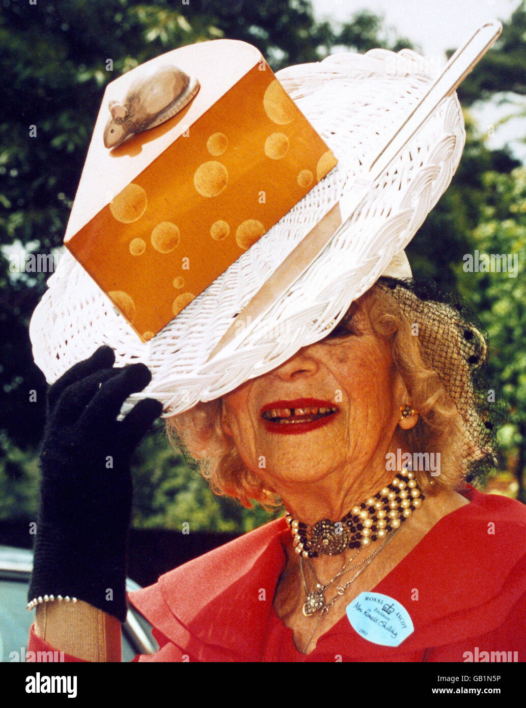 Mode - Hüte - Royal Ascot. Gertrude Shilling trägt eine der Kreationen ihres Sohnes, David Shilling, einen Hut mit Käse, eine Maus und ein Messer. Stockfoto