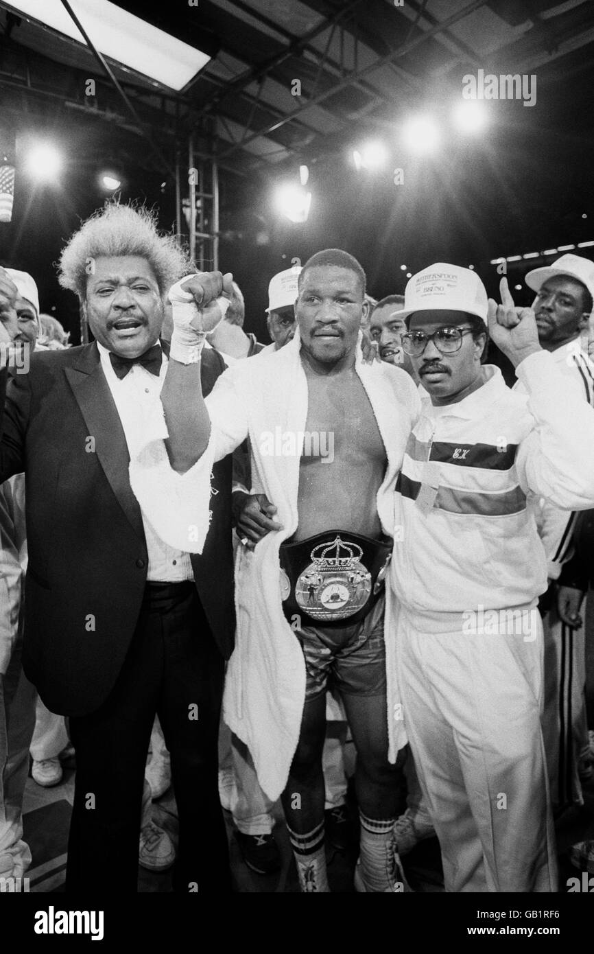 Ein siegreicher Tim Witherspoon feiert mit seinem promotor Don King nach dem Bodenbelag Frank Bruno in der 11. Runde, um seinen WBA-Titelgürtel im Wembley-Stadion zu behalten. Stockfoto