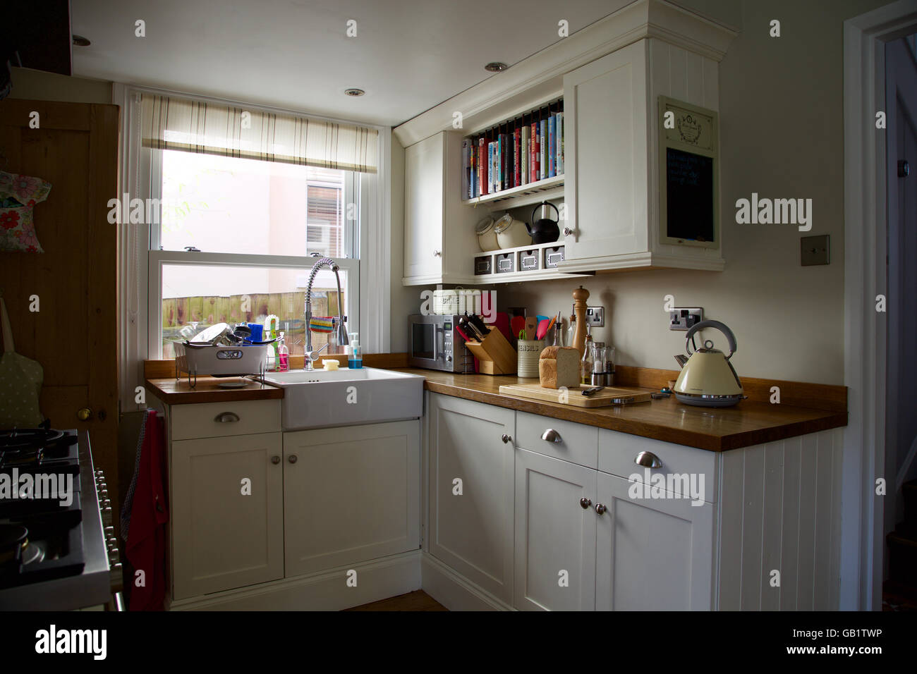Viktorianische Kochnische mit Fenster in echte familiäre Haus Wasserkocher Laib Brot Board Creme Waschbecken Schränke Arbeitsplatte Frühstück toast Stockfoto