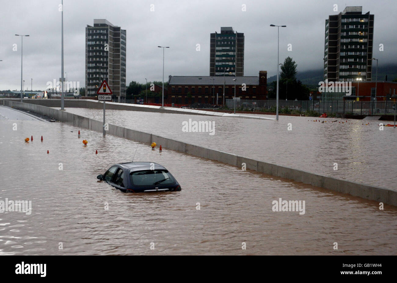 Ein Autofahrer wird bei den schweren Überschwemmungen im Westlink-Gebiet von Belfast, Nordirland, gefangen. Stockfoto