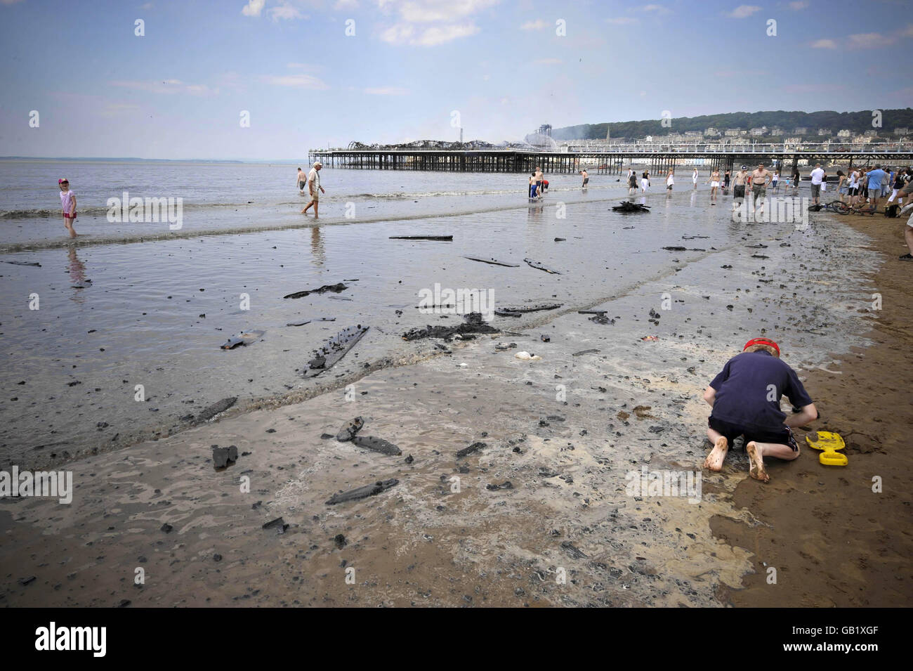 Verbrannte Trümmer werden am Strand neben dem Grand Pier in Weston-super-Mare nach einem Großbrand aufgespült. Stockfoto