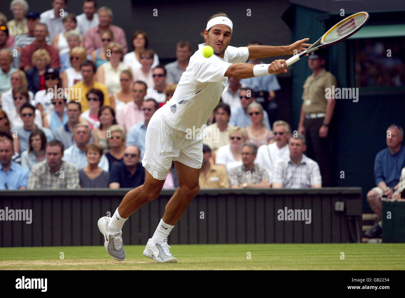 Tennis - Wimbledon 2003 - Herren-Finale - Mark Philippoussis gegen Roger Federer. Roger Federer streckt sich, um eine Rückkehr zu machen Stockfoto