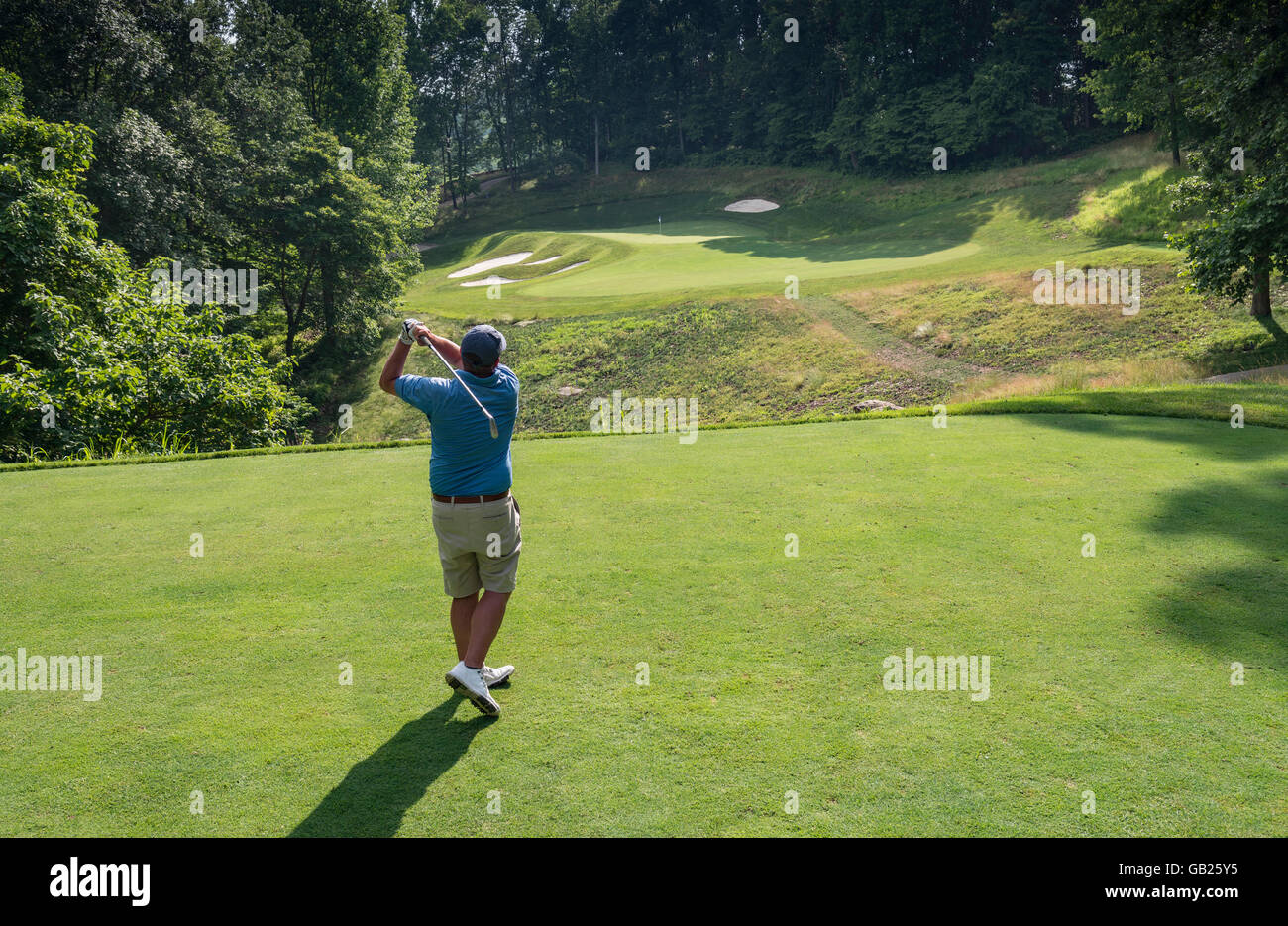 Ansicht von hinten Golfer als er Golf Abschlag schwingt Stockfoto