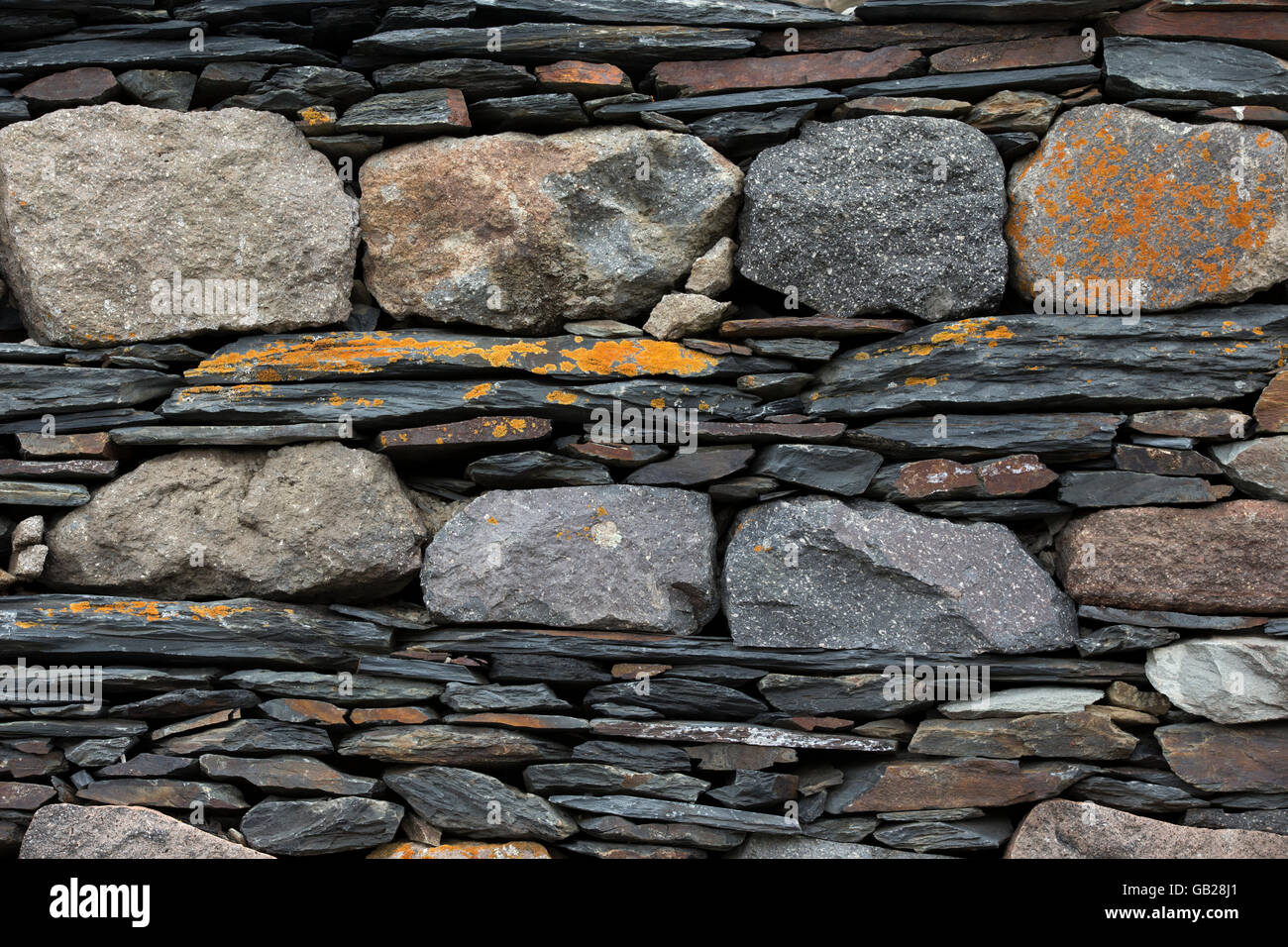 Wand, bestehend aus verschiedenen Stücken aus Basalt mit Flechten bedeckt Stockfoto