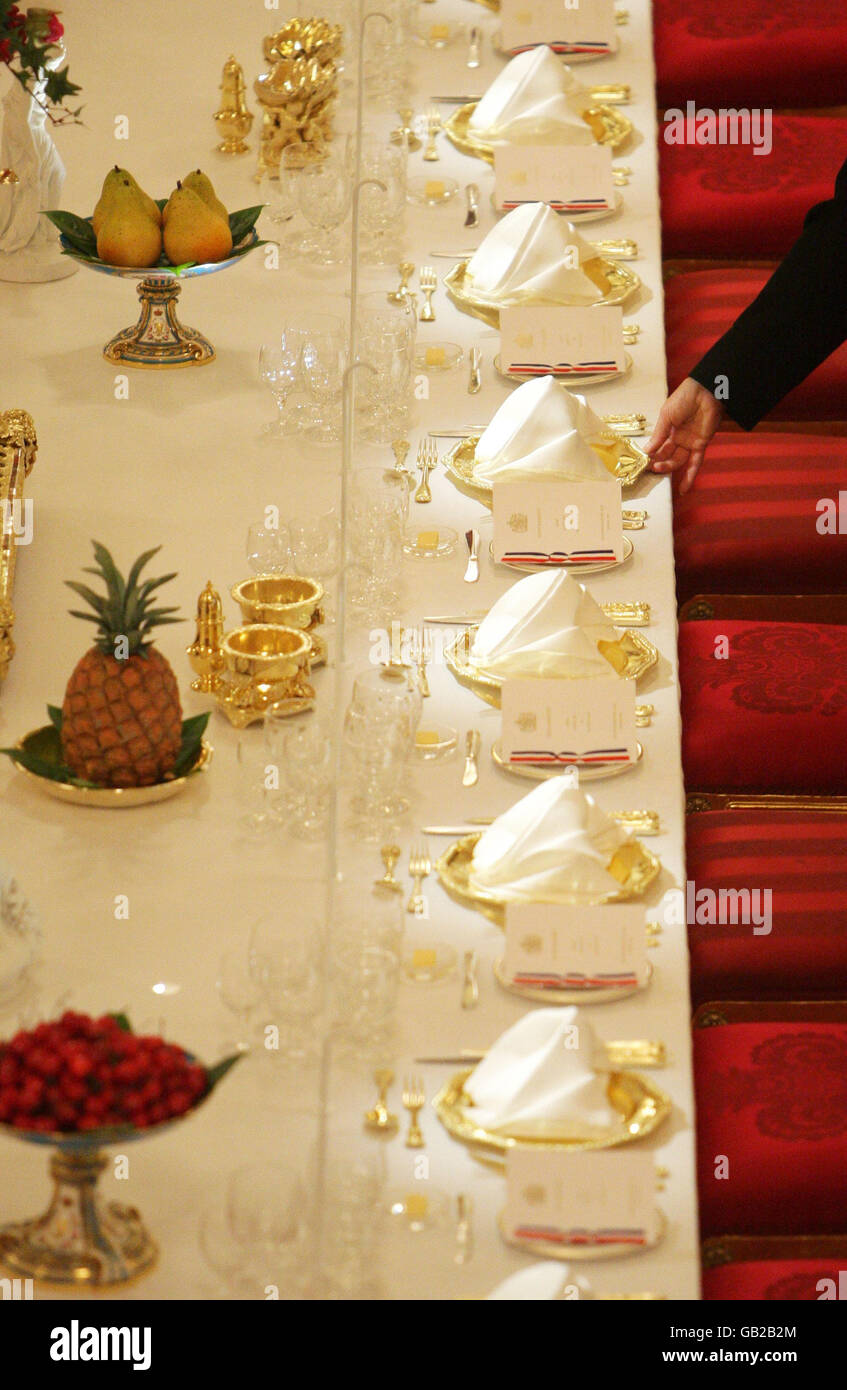 Vor der Sommereröffnung des Königshauses für die Öffentlichkeit legt ein Mitarbeiter den Festtisch des State Banquet im Ballsaal des Buckingham Palace in London ab. Stockfoto