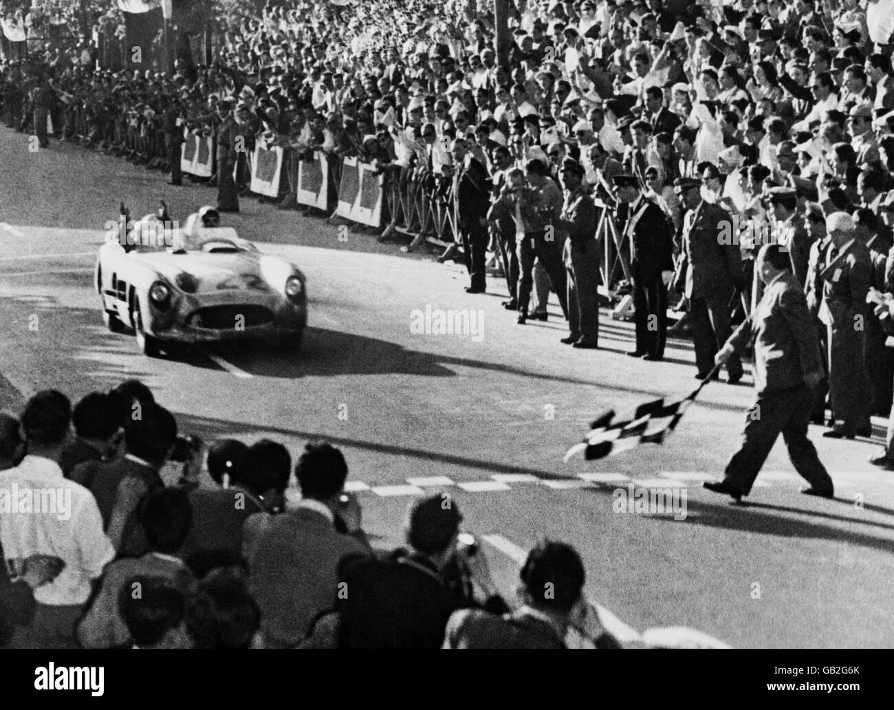 Stirling Moss, der große britische Fahrer, gewann als erster Brite das große italienische Rennen, die Mille Miglia, ein Rennen, das den größten Teil Italiens abdeckt, das er in 10 Stunden, 7 Minuten und 46 Sekunden mit seinem deutschen Mercedes Benz 994 Meilen zurücklegte, um einen neuen Rekord zu stellen. Bild zeigt Moss beim Überqueren der Ziellinie. Stockfoto
