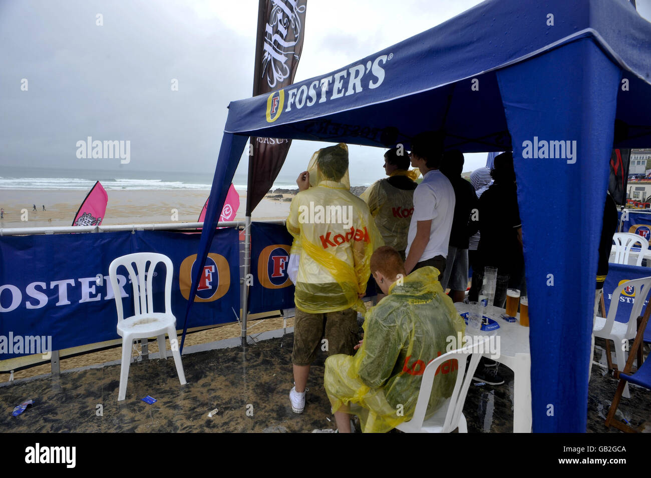 Bei nassem und regnerischem Wetter tragen die Leute Regenponchos im Rip Curl Boardmasters 2008 am Fistral Beach, Newquay. Stockfoto