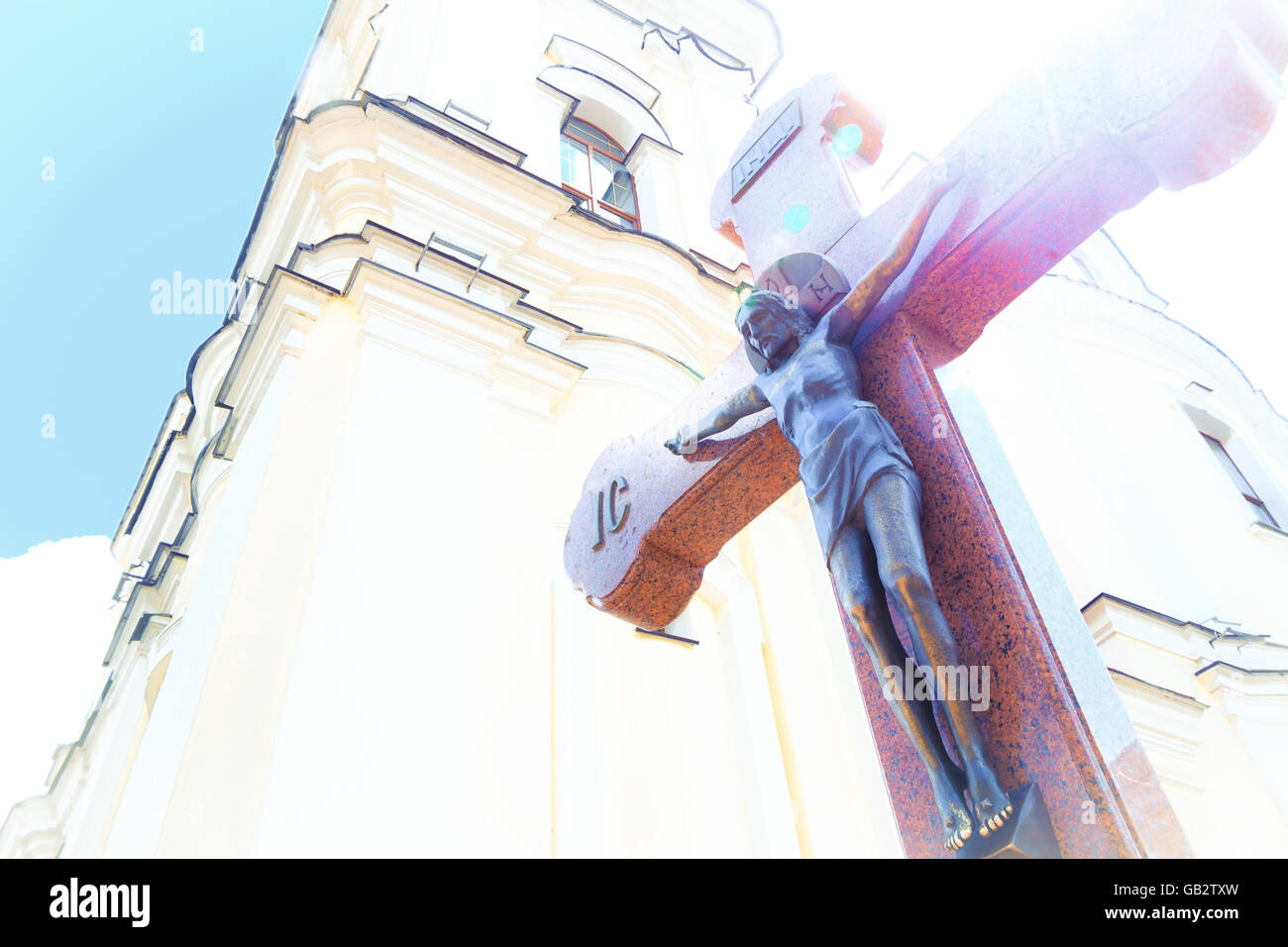 Jesus am Holzkreuz im Hintergrund der Kirche mit Blick auf Sonnenschein Stockfoto